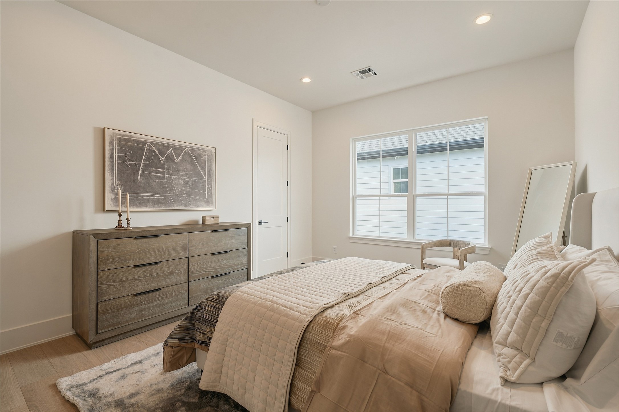 This secondary bedroom feels bright and inviting, with well-proportioned dimensions and a large window creating a comfortable retreat for family or overnight guests.