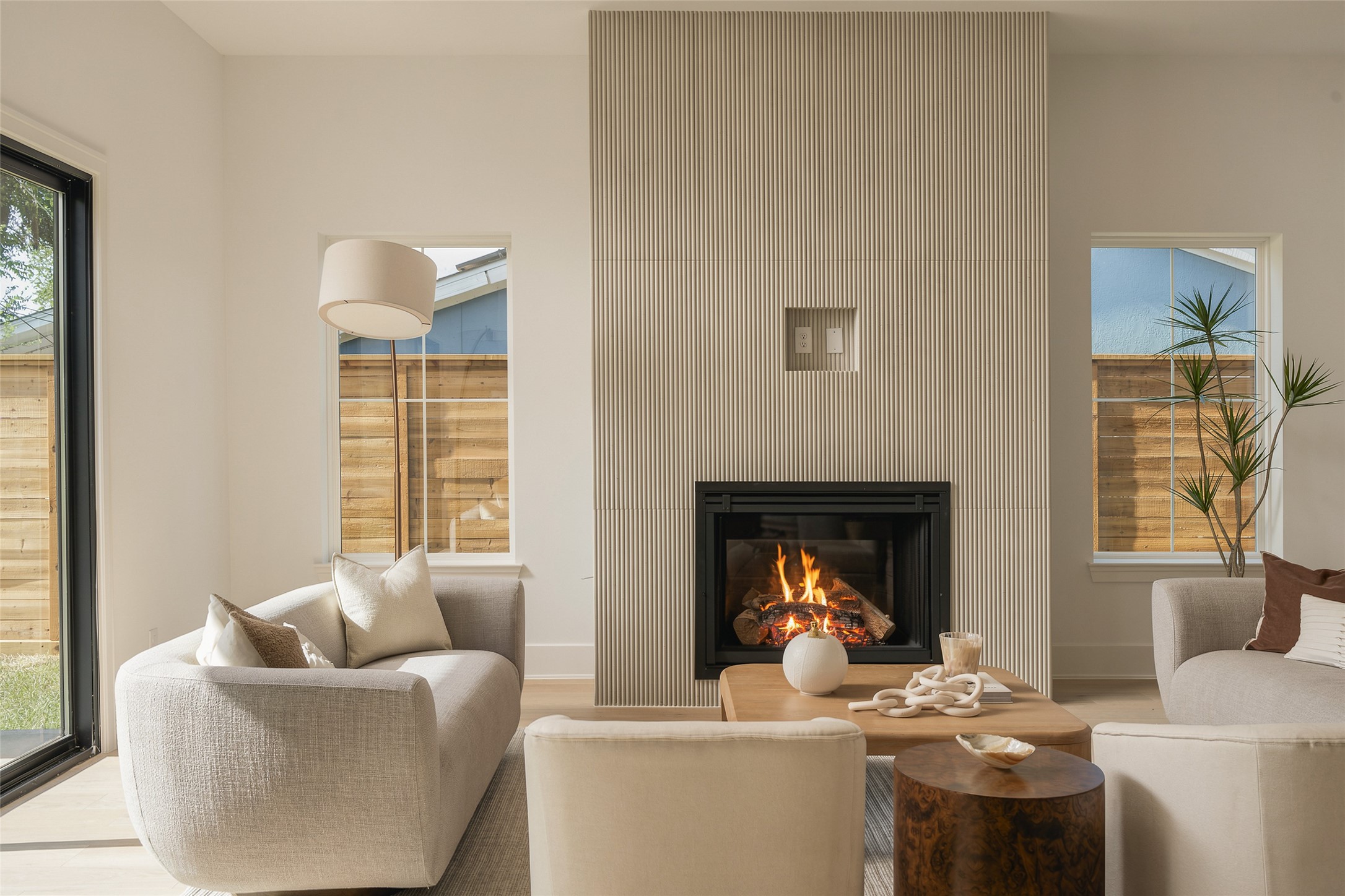 The dining and living spaces flow together beneath 11-foot ceilings, while expansive glass doors draw the eye toward the covered patio and backyard beyondcreating a seamless setting for indoor-outdoor entertaining.