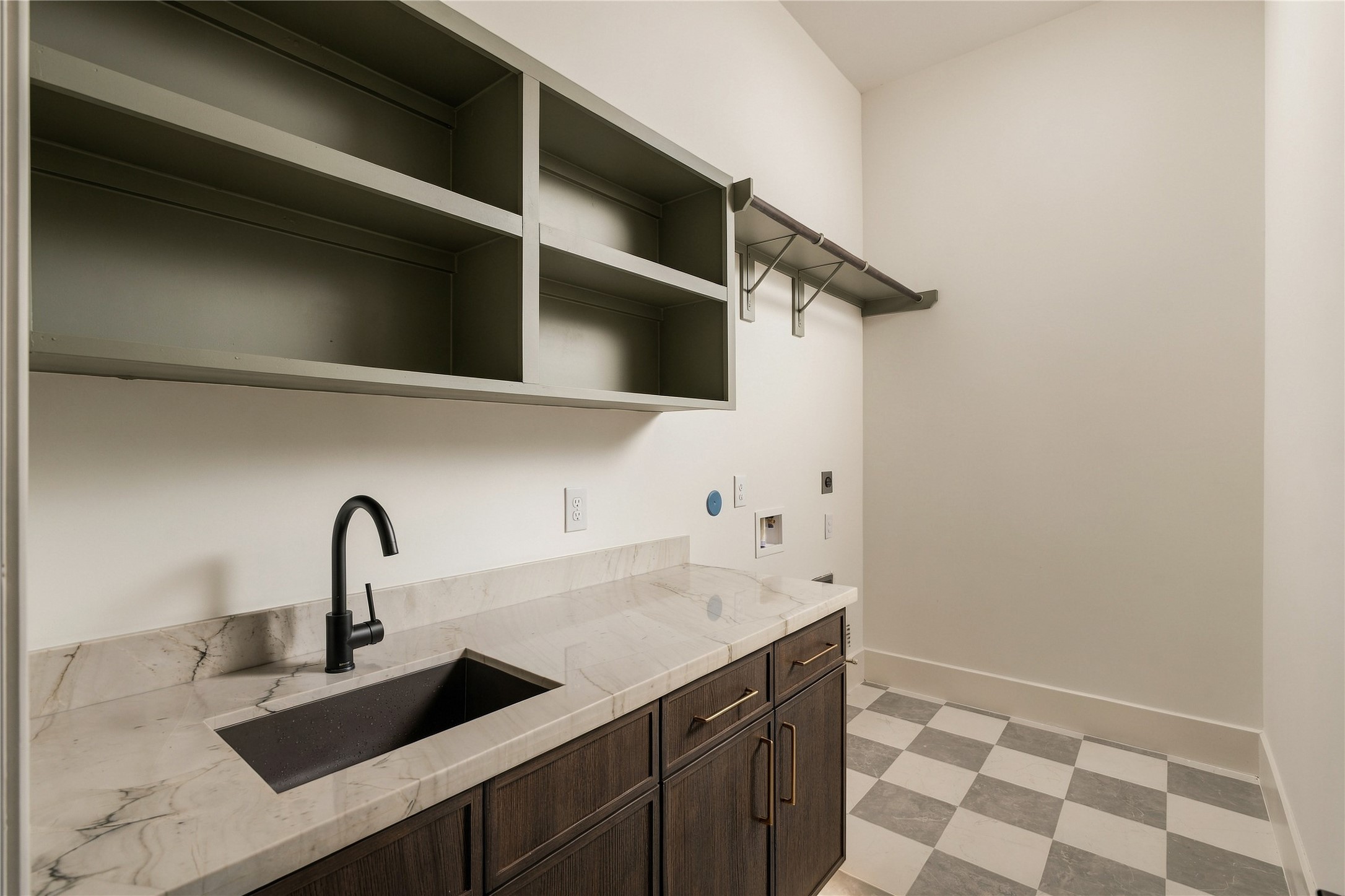 Designed to make daily routines more convenient, the utility room offers ample countertop space, upper and lower storage, and a dedicated area for laundry appliances.