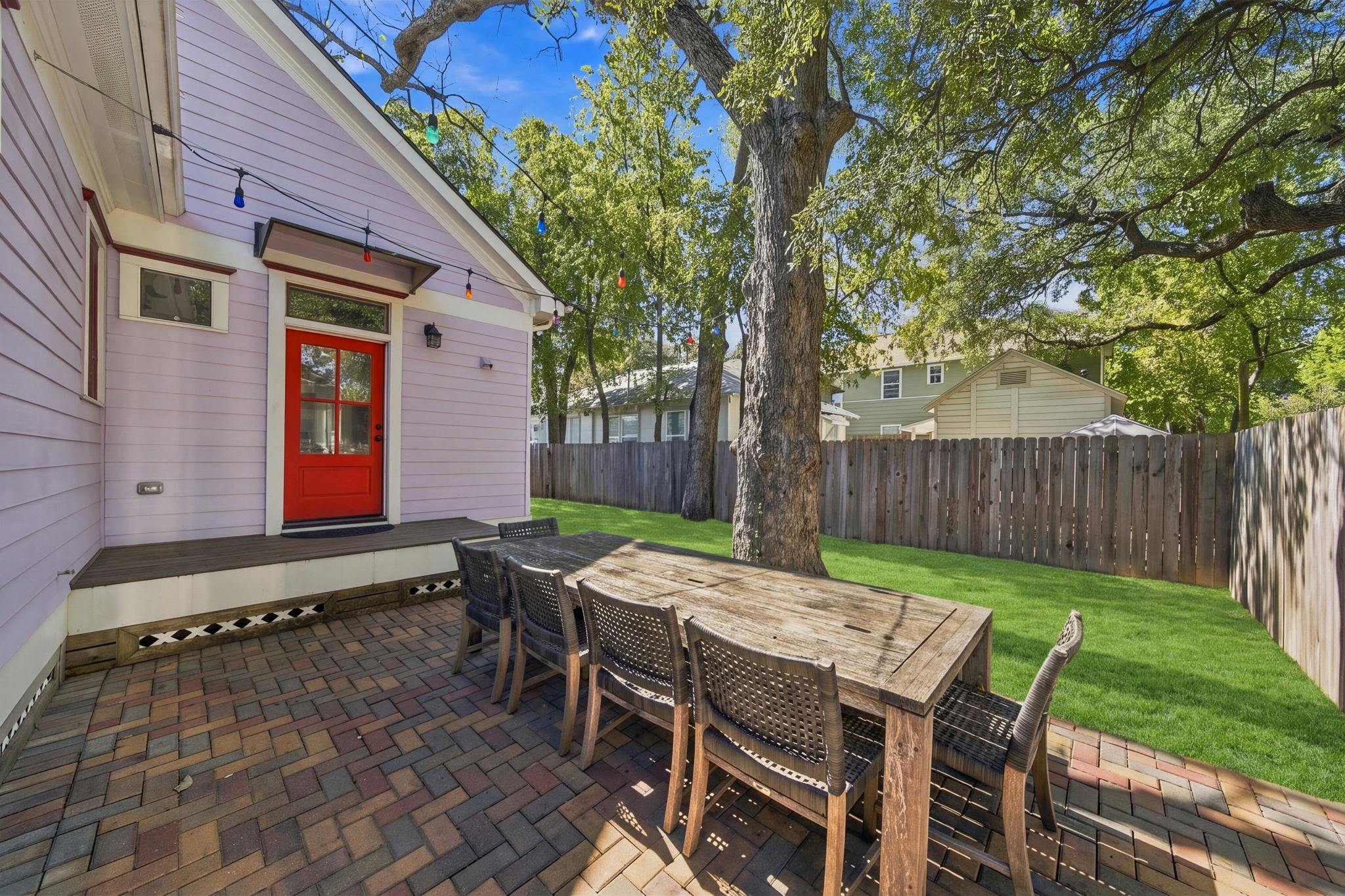 Back patio area with plenty of mature trees. Canopy above the backdoor to protect from the elements. Note that the grass on the property has been virtually in-filled
