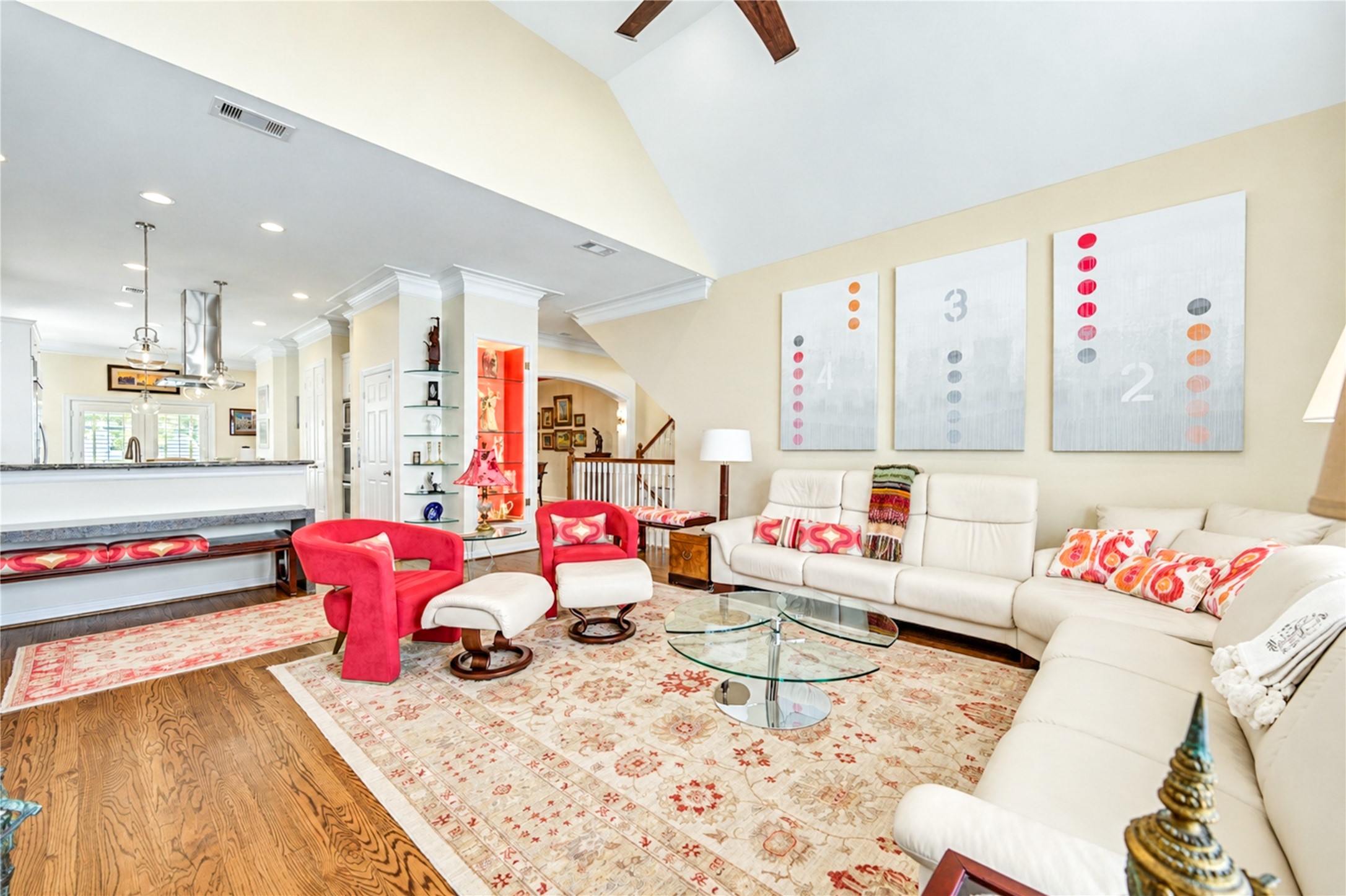 An alternate view showcases the beautiful connection between the vaulted living room and kitchen, framed by architectural columns and warm hardwood flooring. An alternate view showcases the beautiful connection between the vaulted living room and kitchen, framed by architectural columns and warm hardwood flooring.