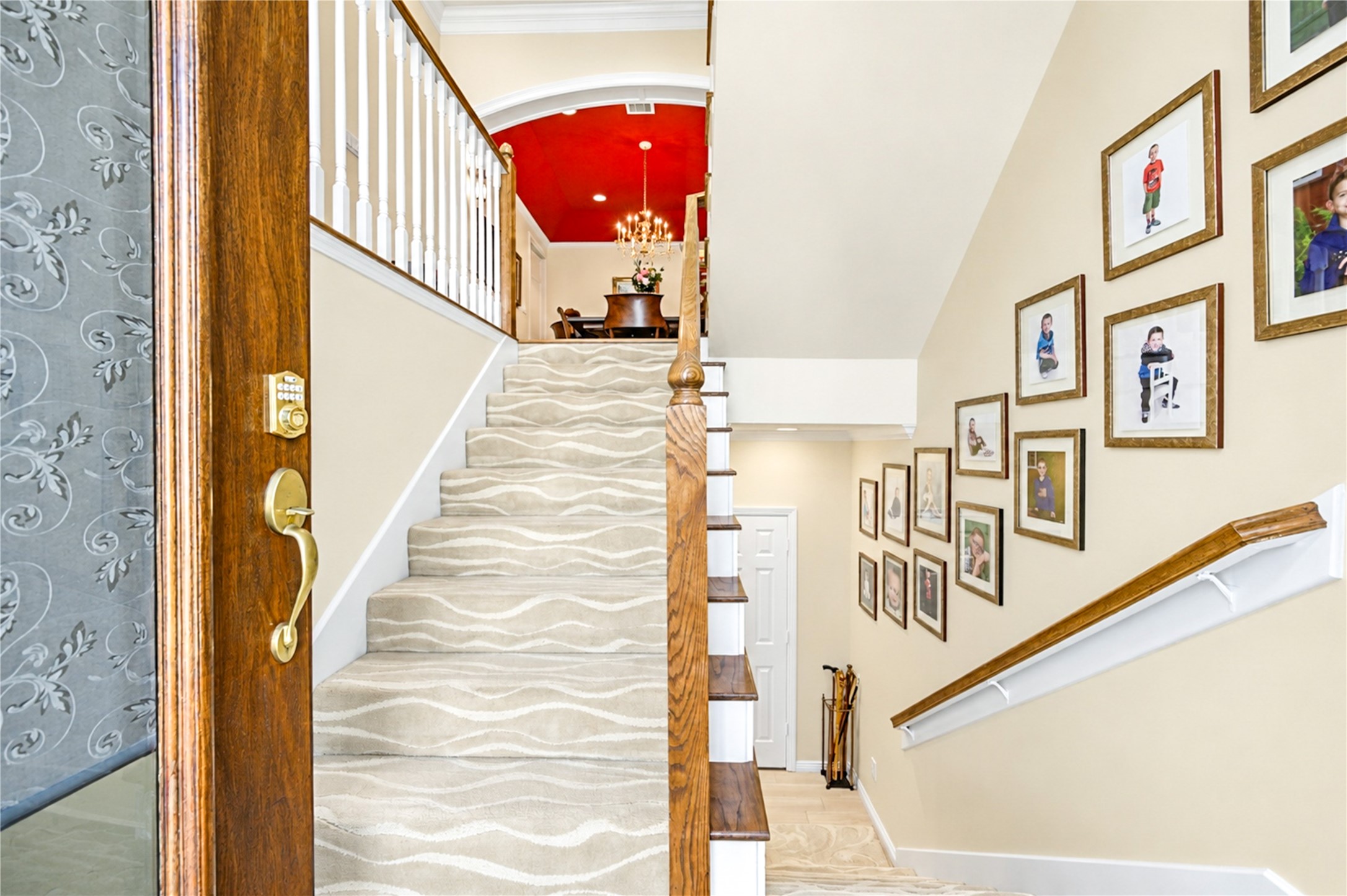 A graceful staircase rises from the entry to the second-floor living areas, offering a glimpse of the dining room's striking red ceiling and chandelier. A graceful staircase rises from the entry to the second-floor living areas, offering a glimpse of the dining room's striking red ceiling and chandelier.