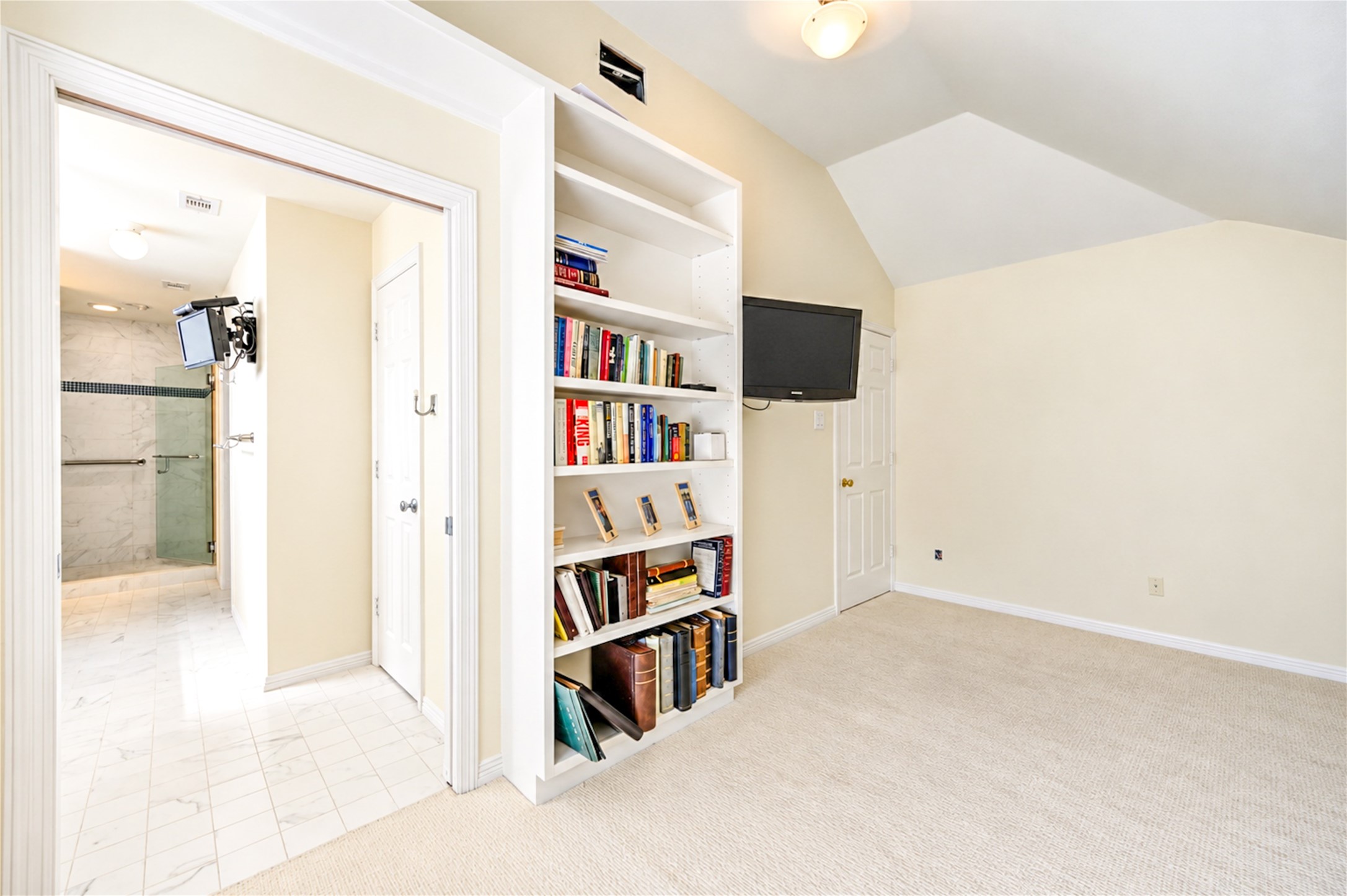 Another perspective highlights the bedroom's custom built-ins and convenient access to the adjoining bathroom.