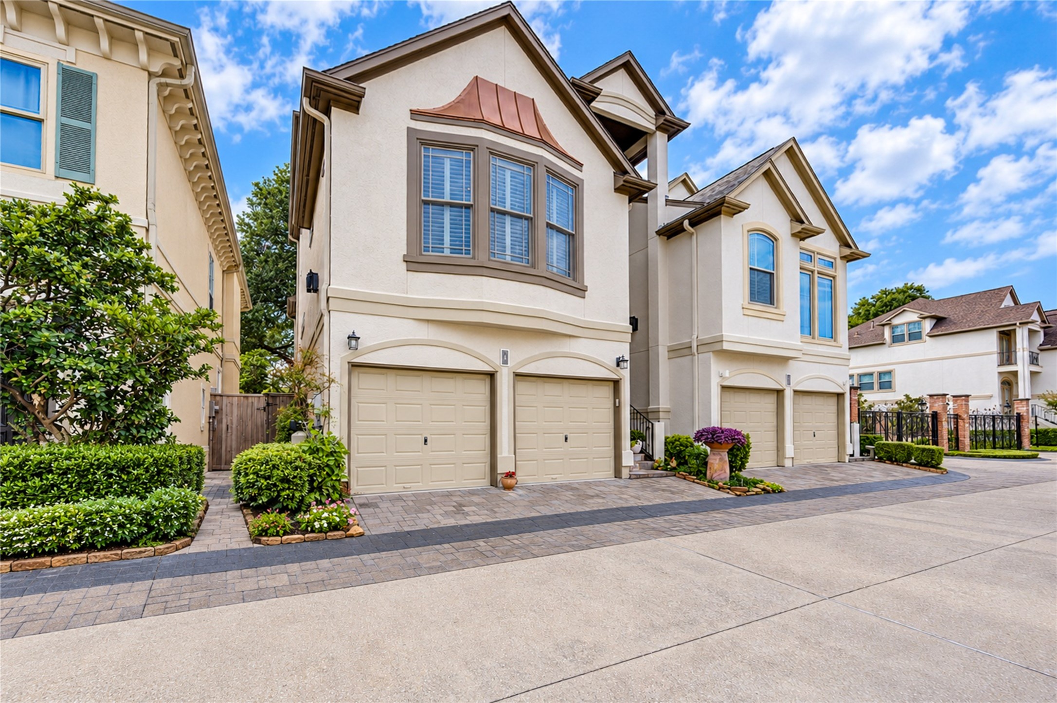An angled view highlights the elegant stucco exterior, arched garage openings and landscaped entrance to this distinctive three-story residence. An angled view highlights the elegant stucco exterior, arched garage openings and landscaped entrance to this distinctive three-story residence.