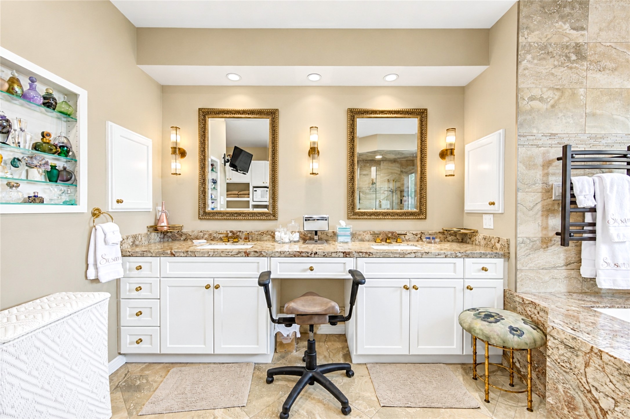 Custom display niches, dual sinks and a heated towel warmer lend the primary bath a spa-like polish.
