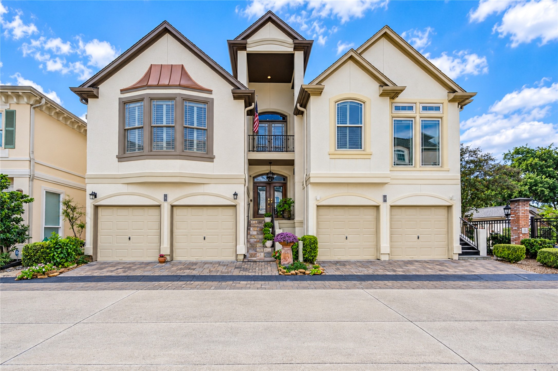 Graceful arched openings and timeless architectural elegance define the stucco exterior of this distinctive three-story residence, nestled within the exclusive gated community of Milan Estates.