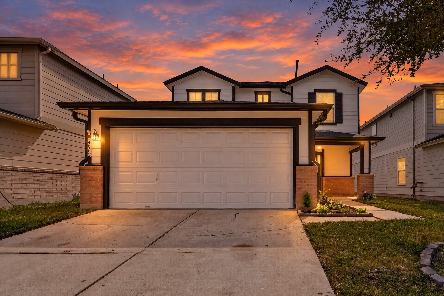 A smooth, spacious driveway leads to the attached two-car garage, providing ample room for parking and a convenient approach to the home.