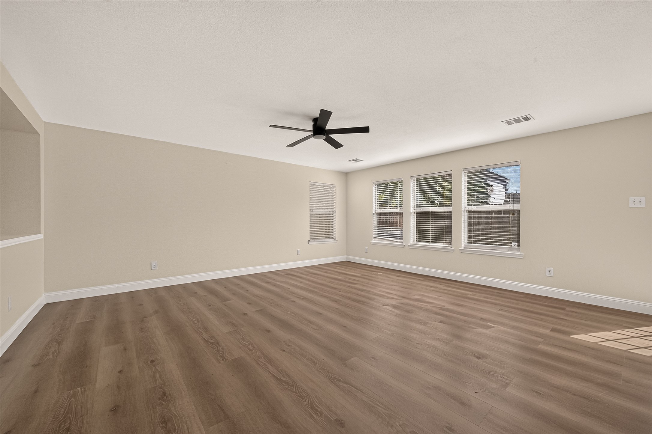 The sizable area opposite the kitchen presents another opportunity to shape the home's layout around your needs, whether as a relaxed lounge or an extension of the main living space. Backyard views bring an outdoor focal point into the room.