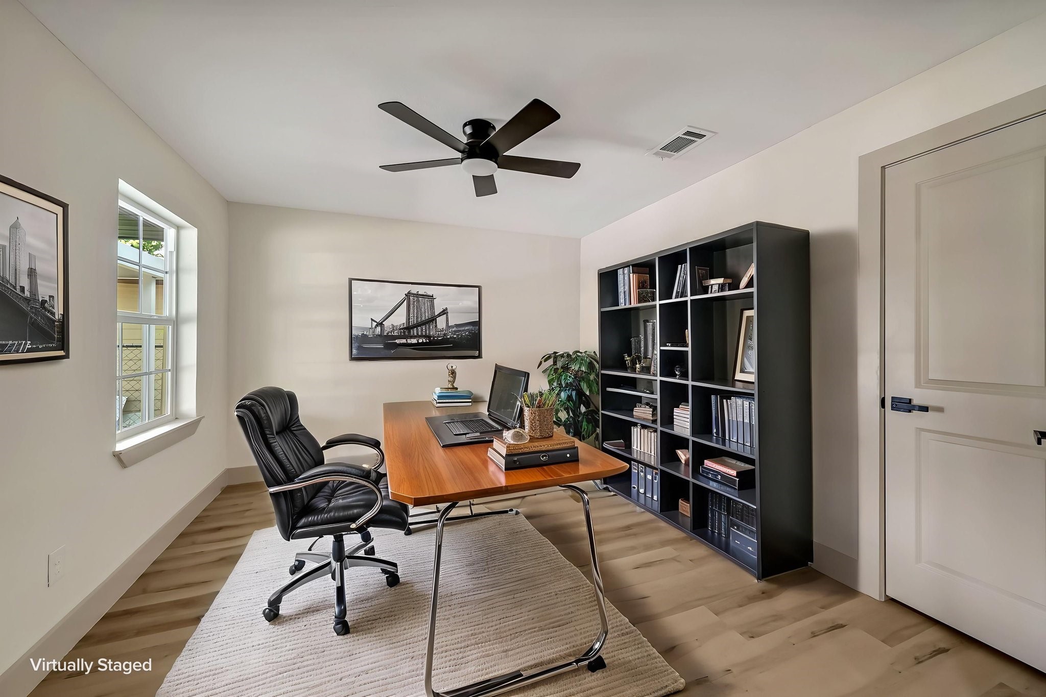 (Photoshopped) This elegantly staged home office/possibility of a 4th bedroom features abundant natural light, sleek modern furnishings, and a spacious bookshelf, creating an inspiring workspace.