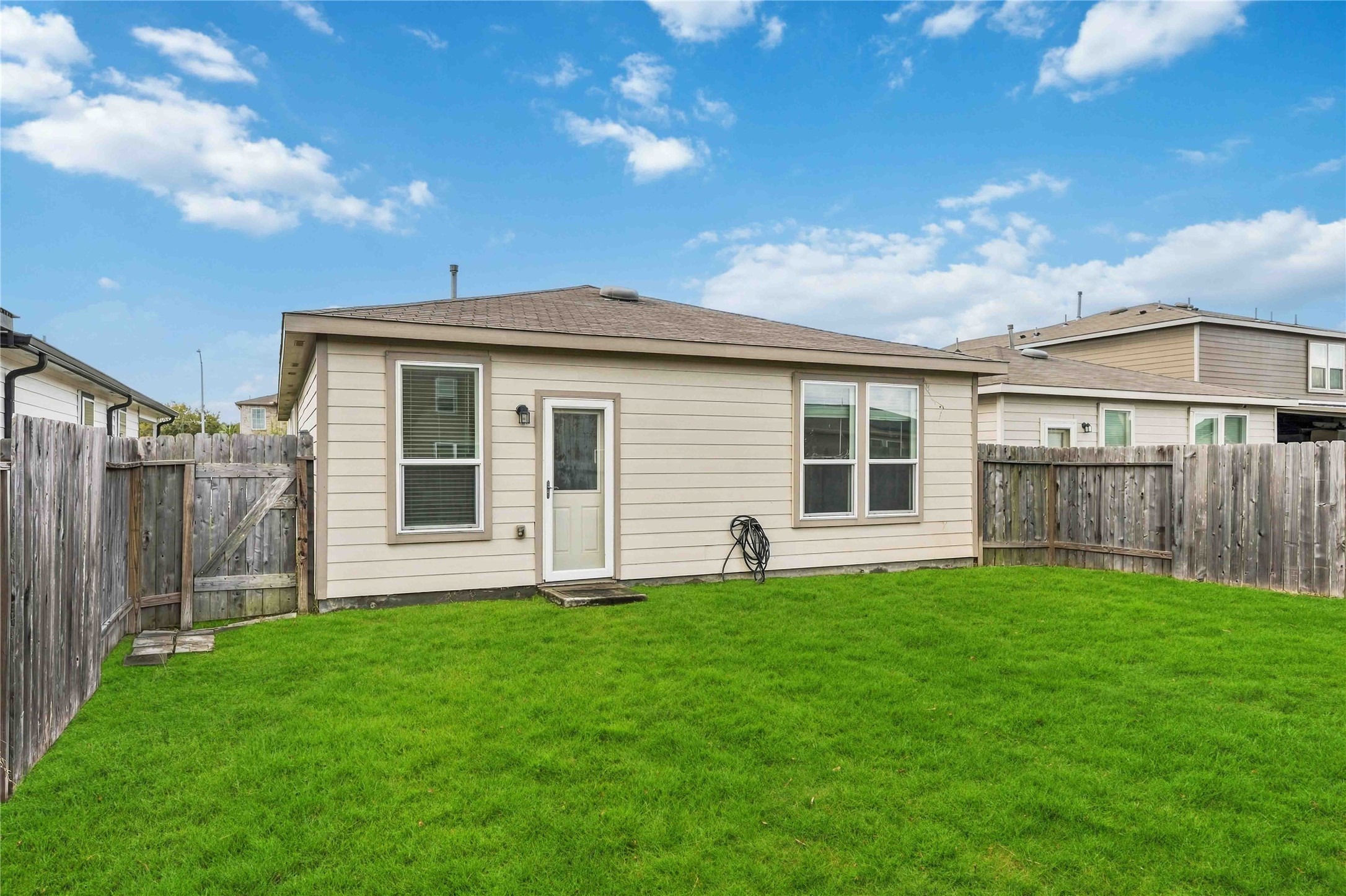 Rear exterior with backyard access and space for outdoor seating.
