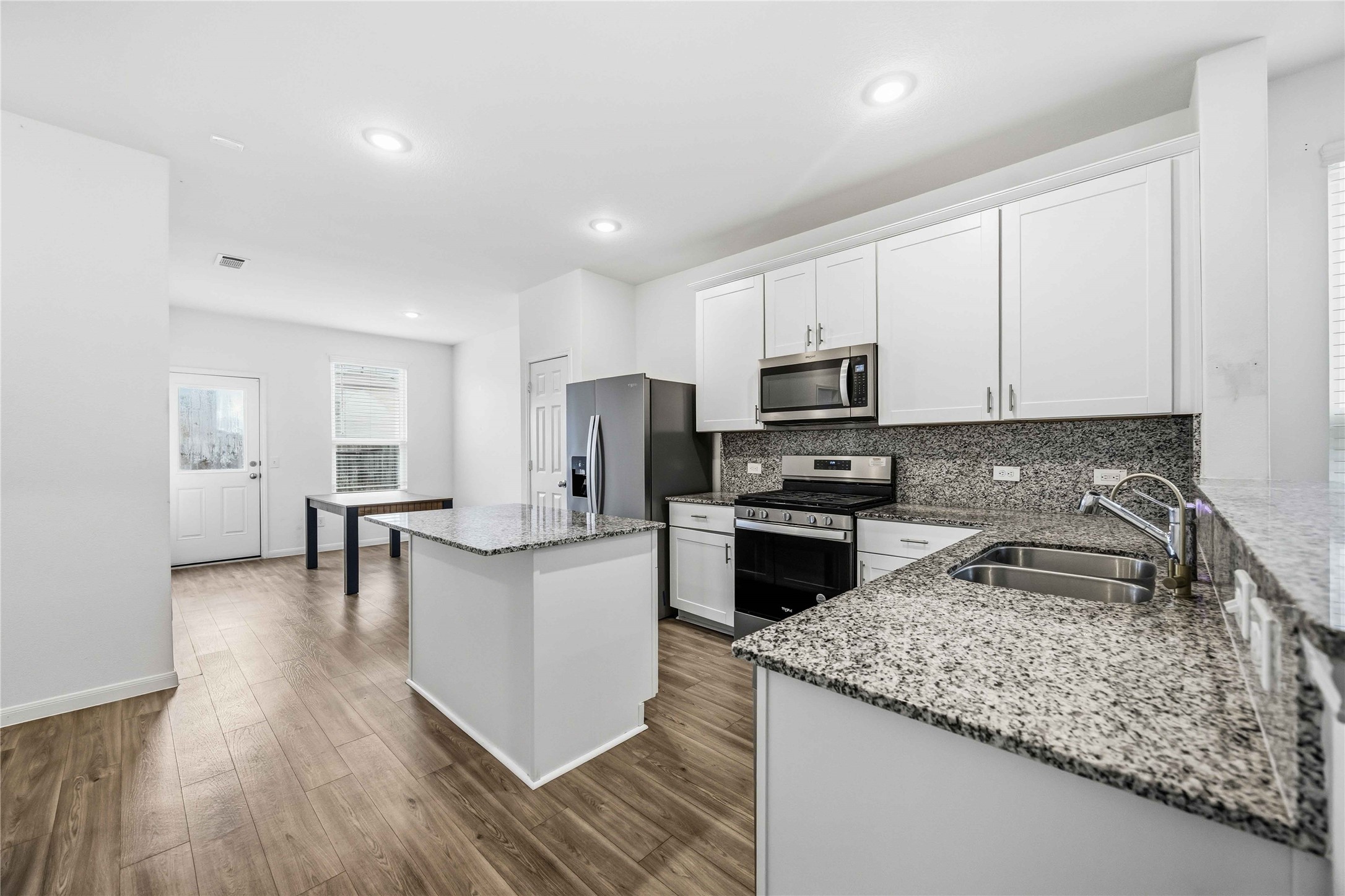 Kitchen featuring white cabinetry, granite countertops, and a center island.