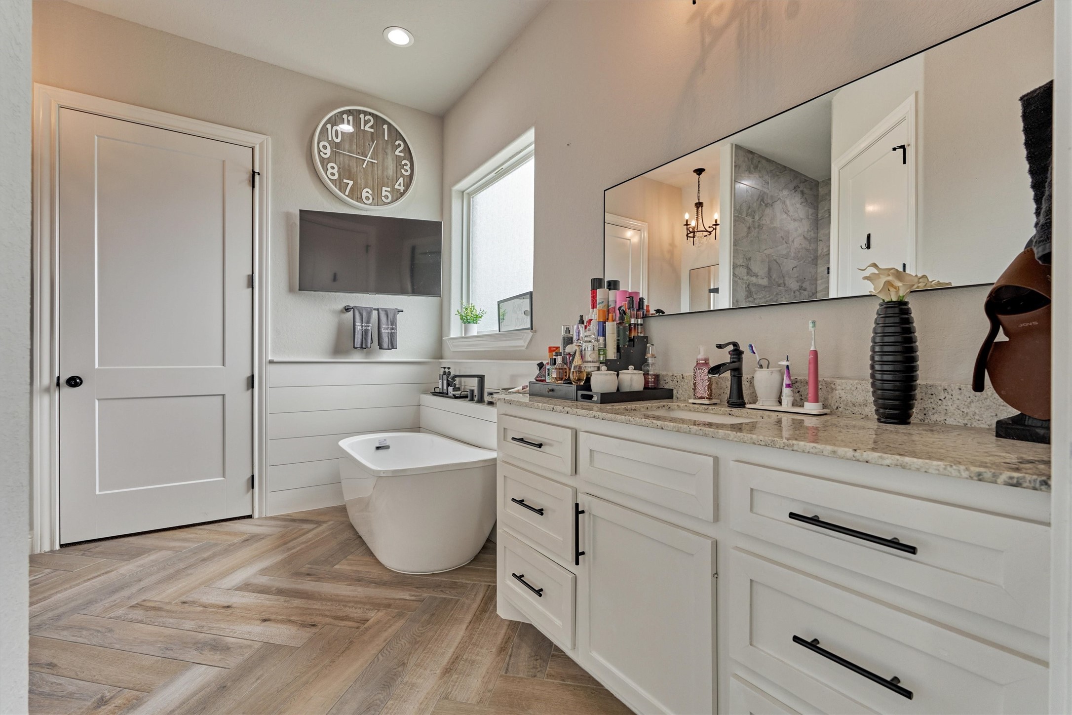 Primary bathroom with stand alone tub, two separate sink areas and a walk in shower.