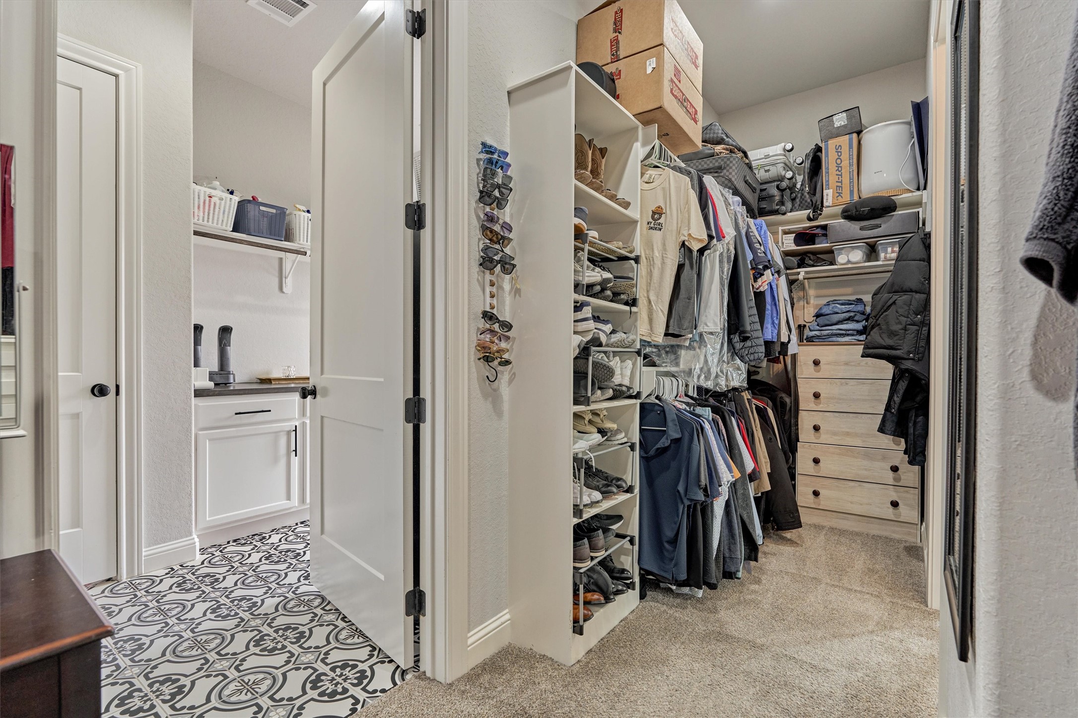 Large primary walk in closet with access directly to the utility room