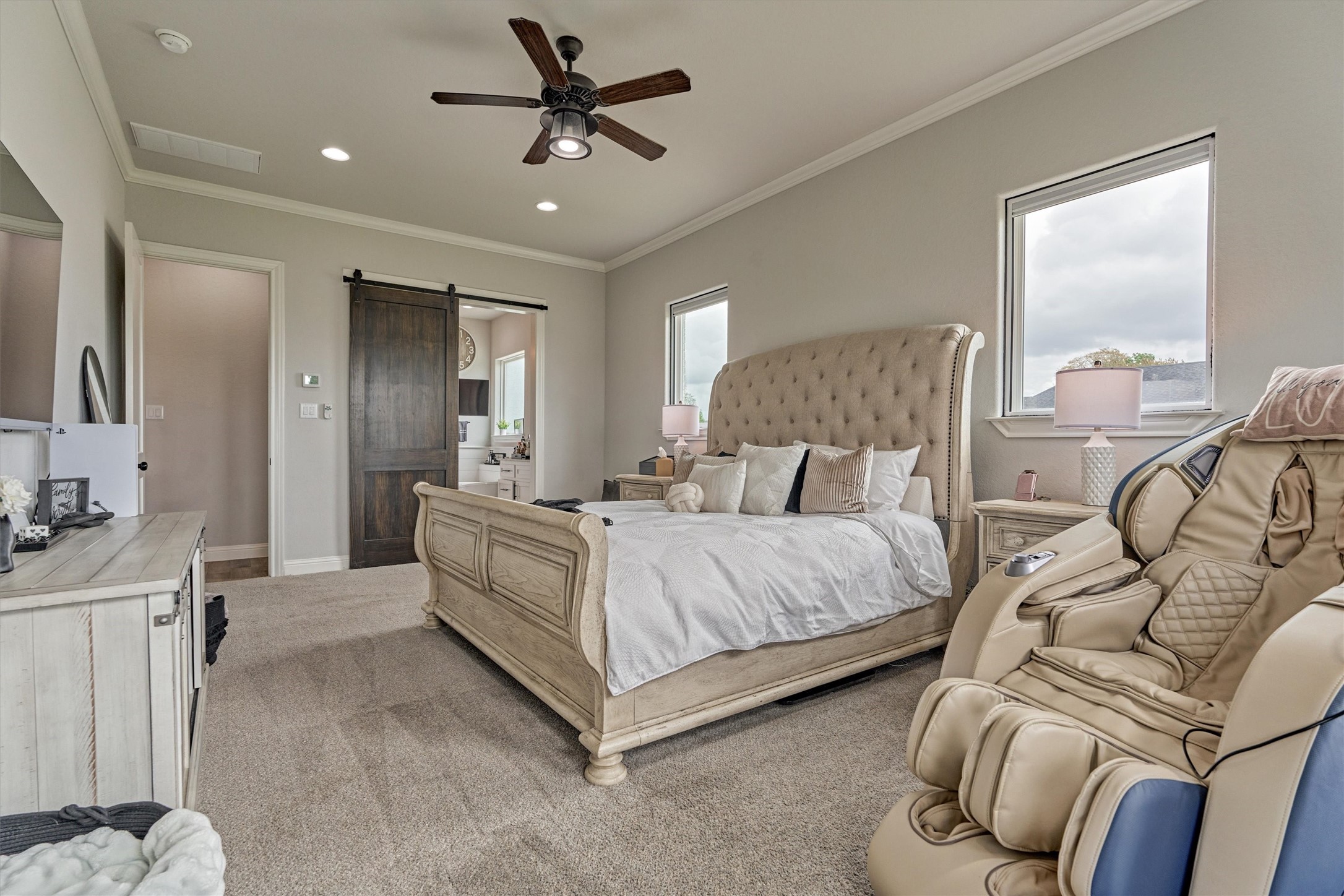 Primary bedroom features high ceilings and large windows.