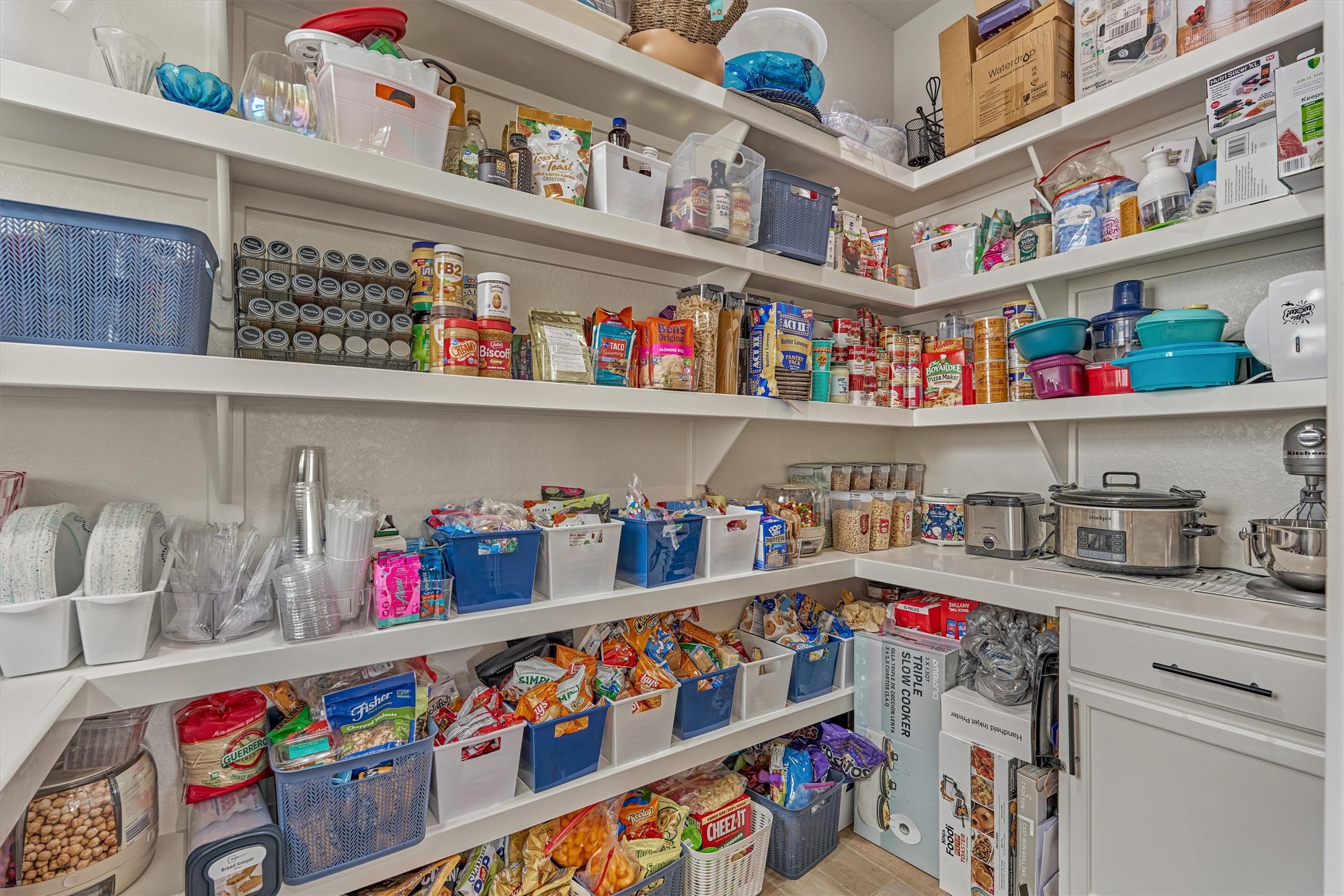 A large walk in pantry with extra cabinet space for appliances.