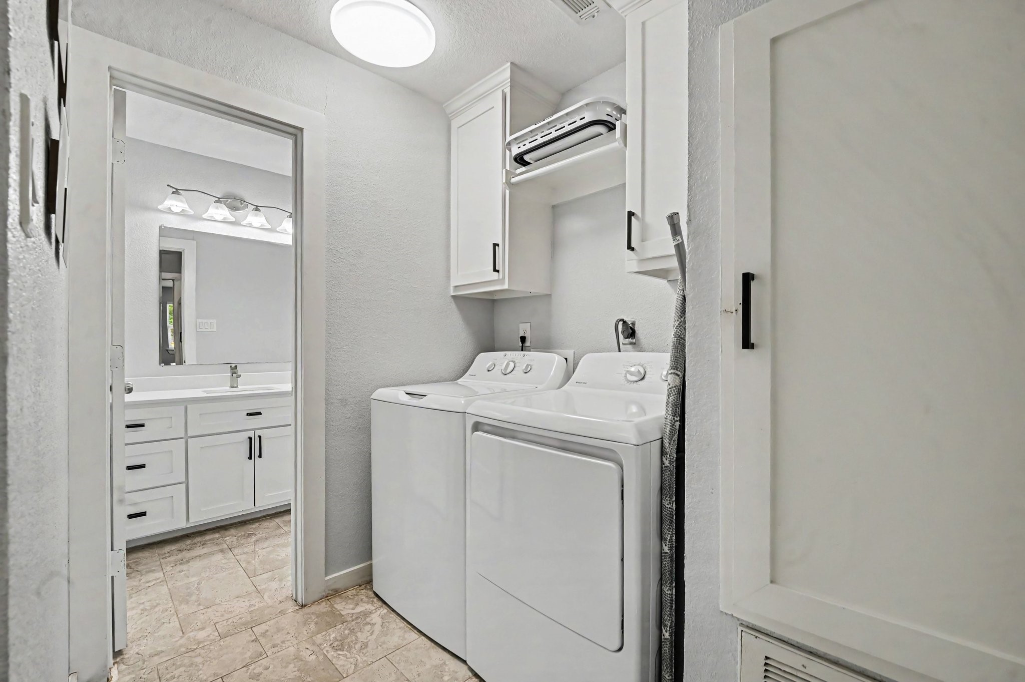 The laundry area is conveniently situated in the hallway next to the secondary bath and it's very spacious and offer plenty of storage.