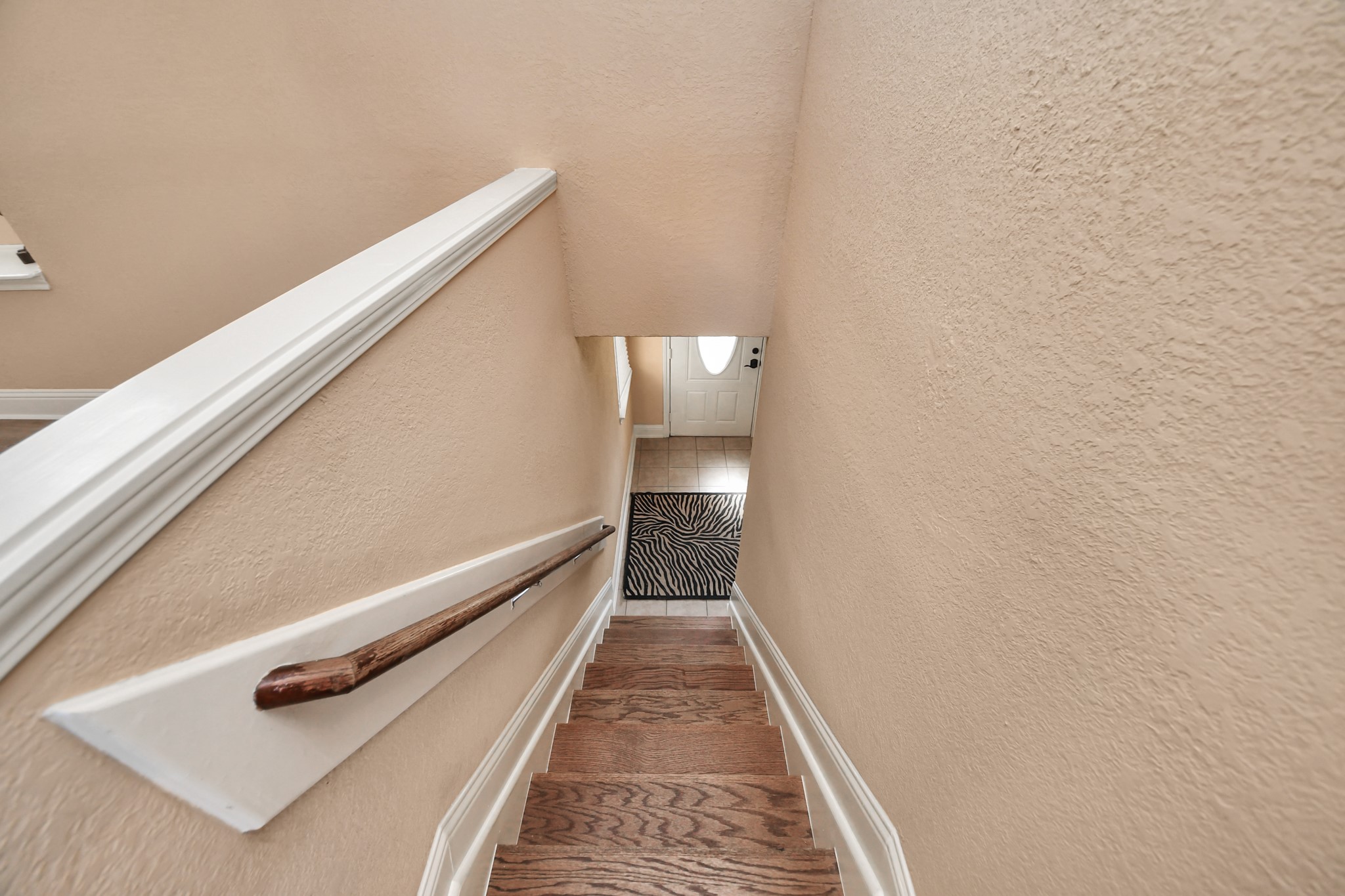 Follow the beautiful wood-look staircase to the lower level, where a thoughtfully designed split-level layout creates a wonderful sense of separation between living spaces.