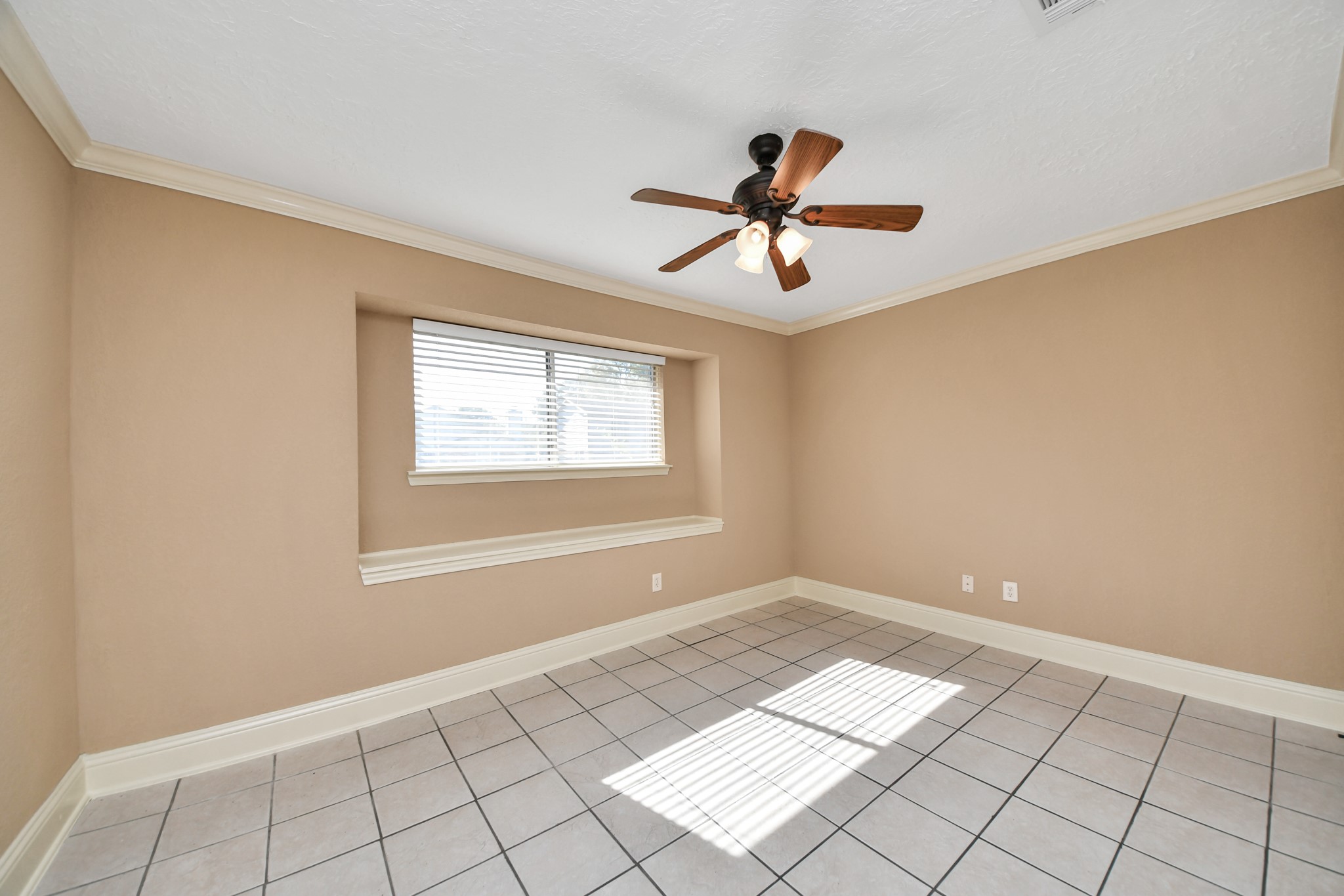 This inviting first-level secondary bedroom offers an abundance of natural light through a charming recessed window, creating a bright and welcoming atmosphere.