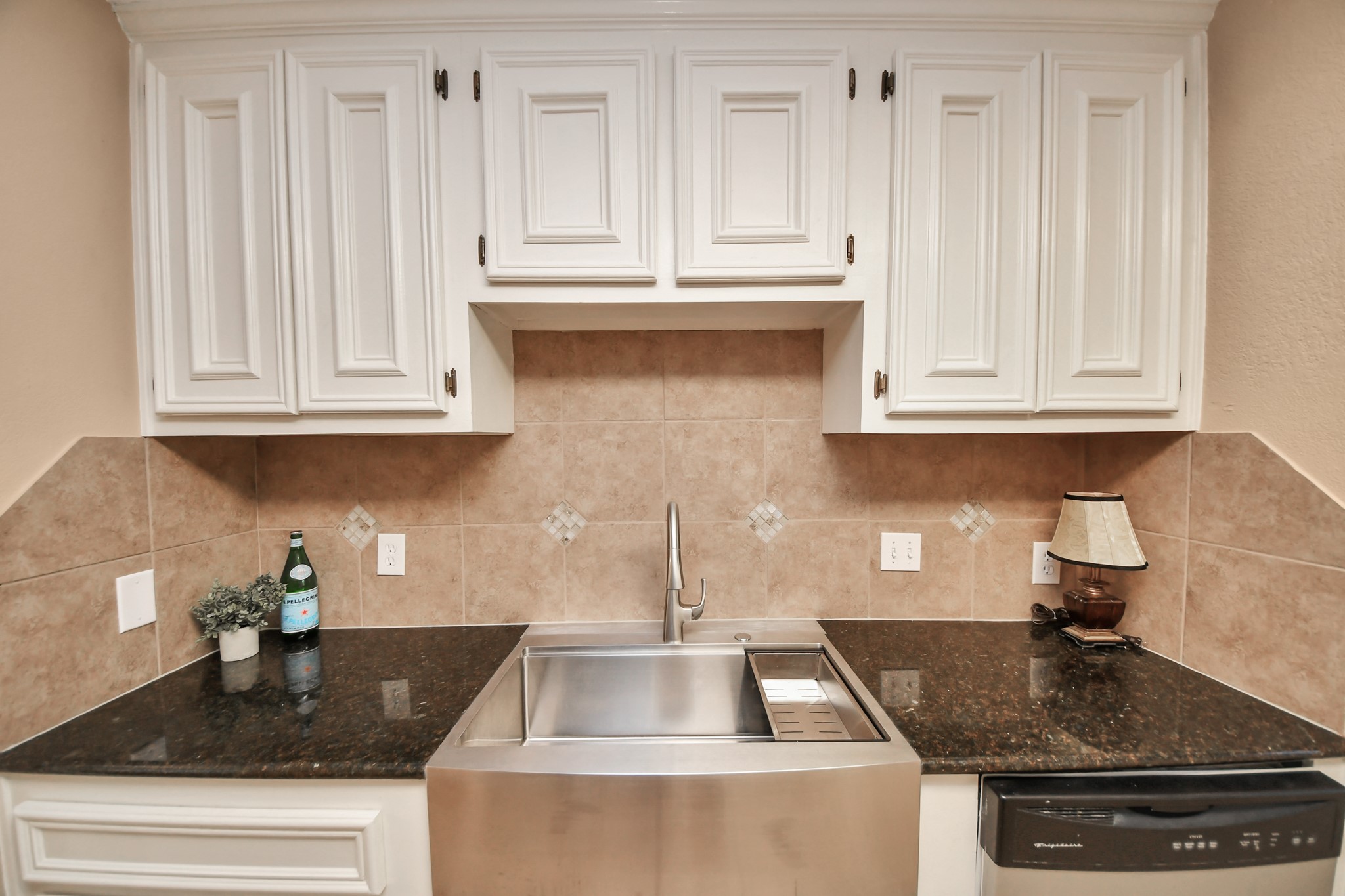 One of the kitchens standout features is its eye-catching stainless steel apron-front sink, combining farmhouse-inspired style with everyday practicality.