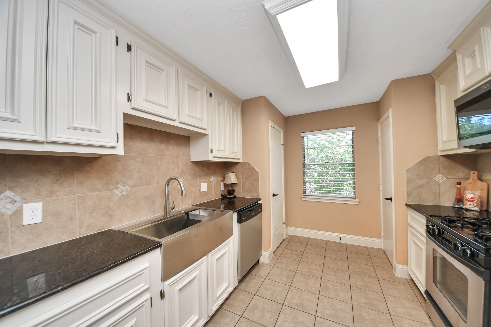 Decorative backsplash accents and crown molding add character, creating an inviting kitchen ready for everything from quick weekday meals to preparing your favorite recipes.