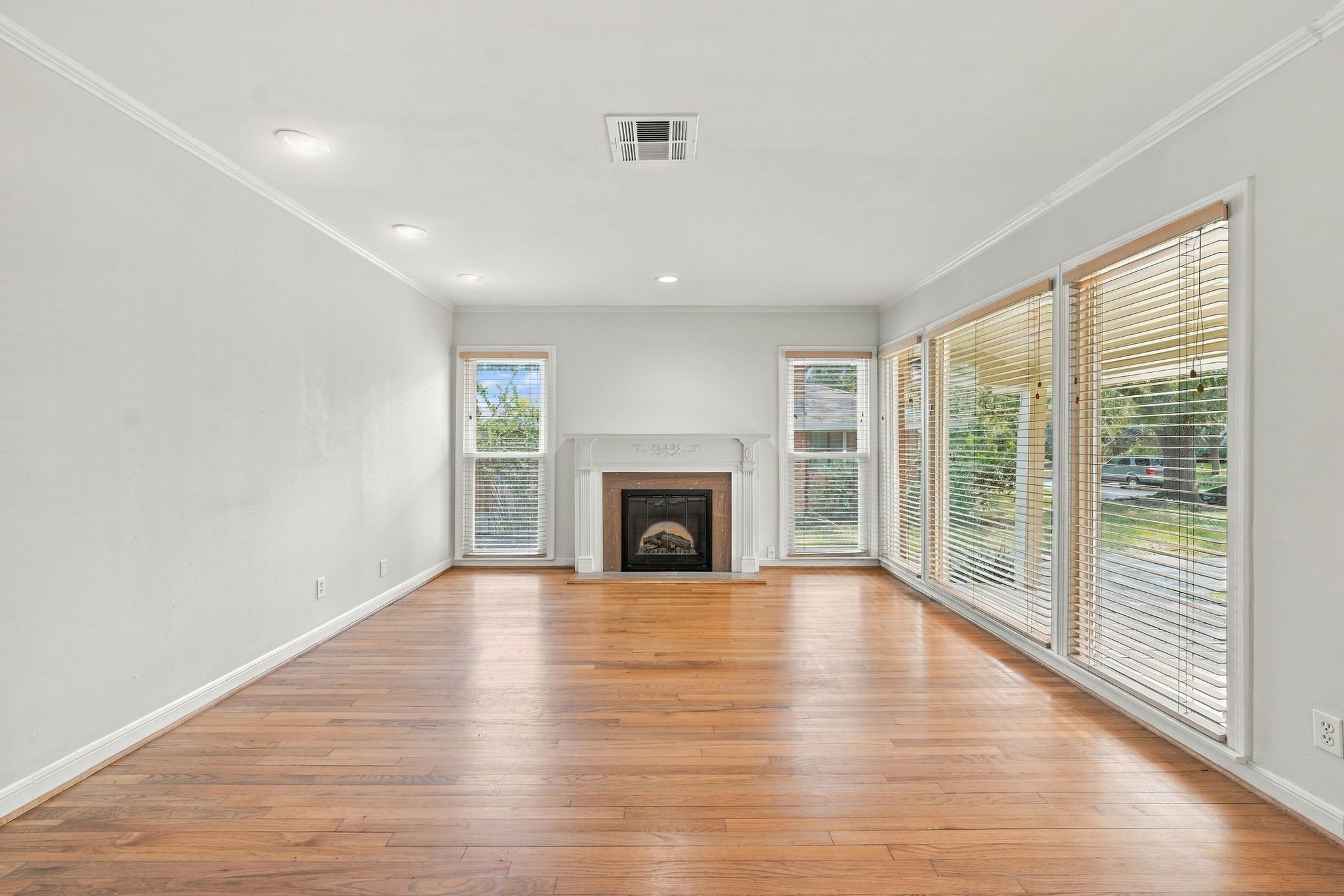 Beautiful original floors, a fireplace and large windows along front wall make for an alluring living room Beautiful original floors, a fireplace and large windows along front wall make for an alluring living room