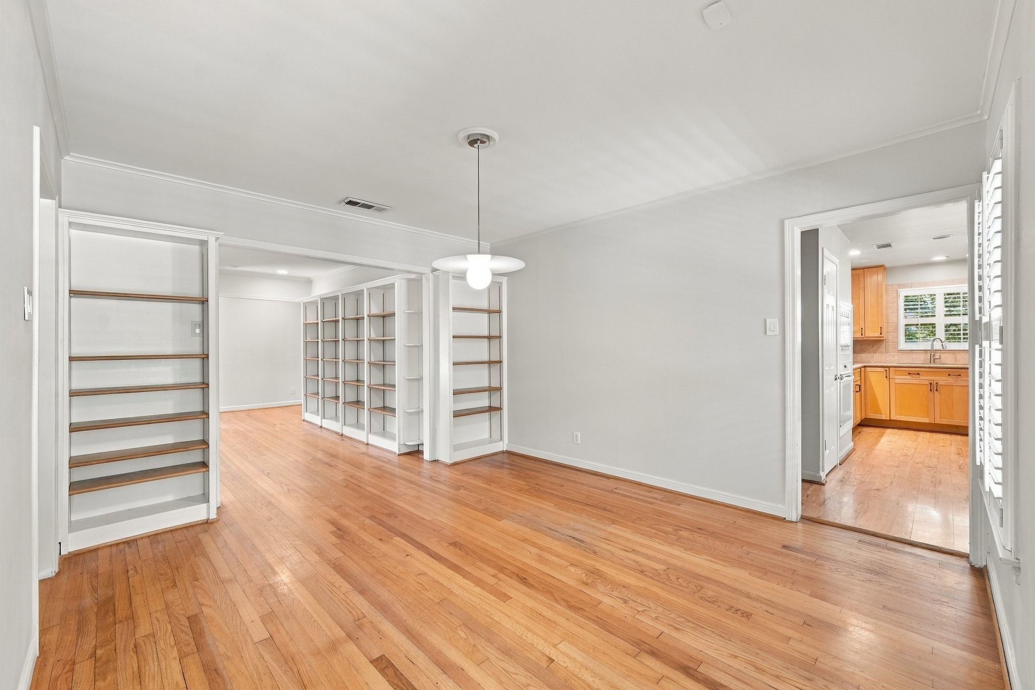 Dining room has built in shelves for tabletop accessories or framed photos. Dining room opens  to kitchen