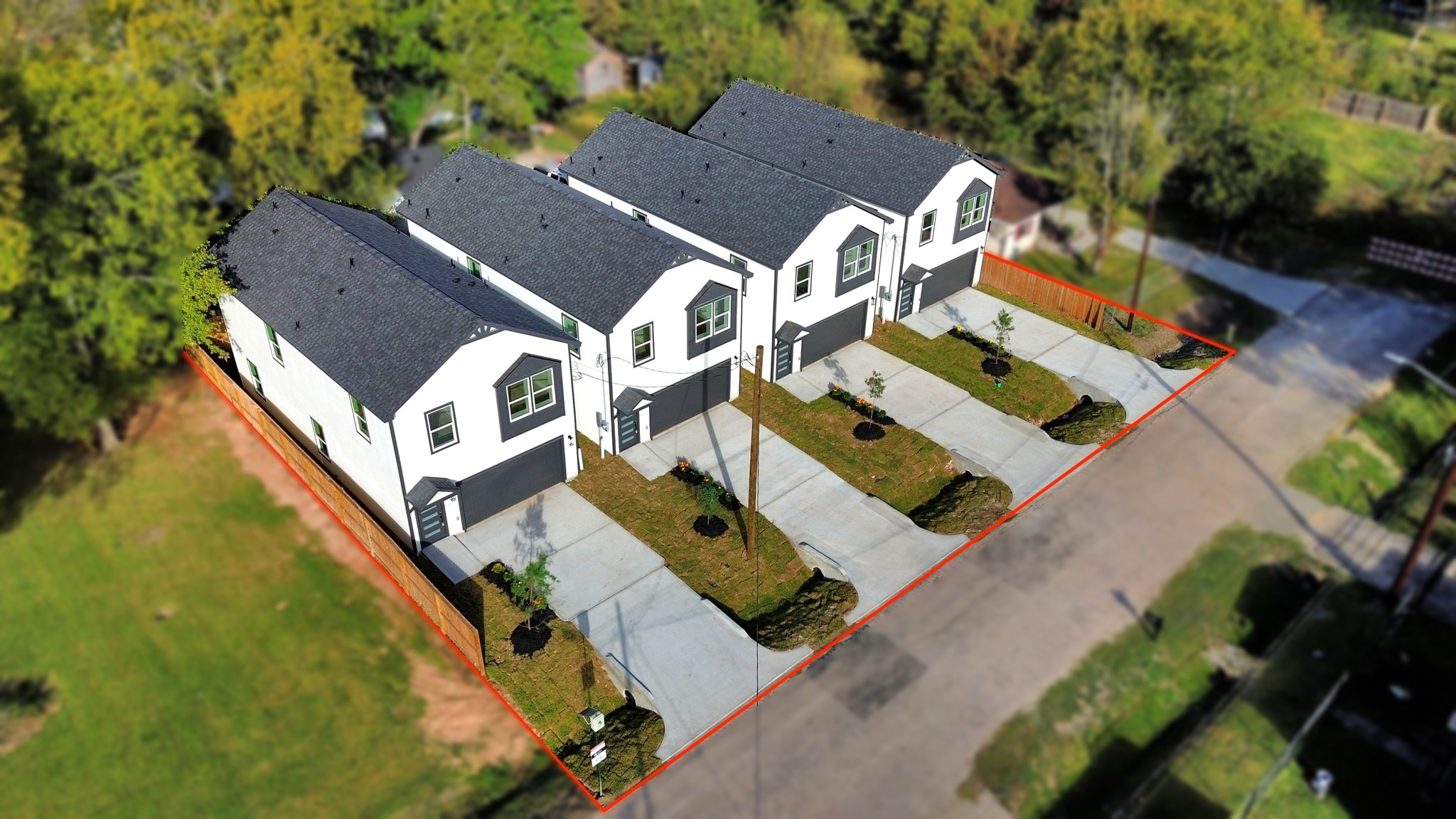 Elevated aerial perspective of all four newly completed Athelya Homes, showcasing their attractive modern exteriors, 2-car garages, private driveways & landscaped front yards.