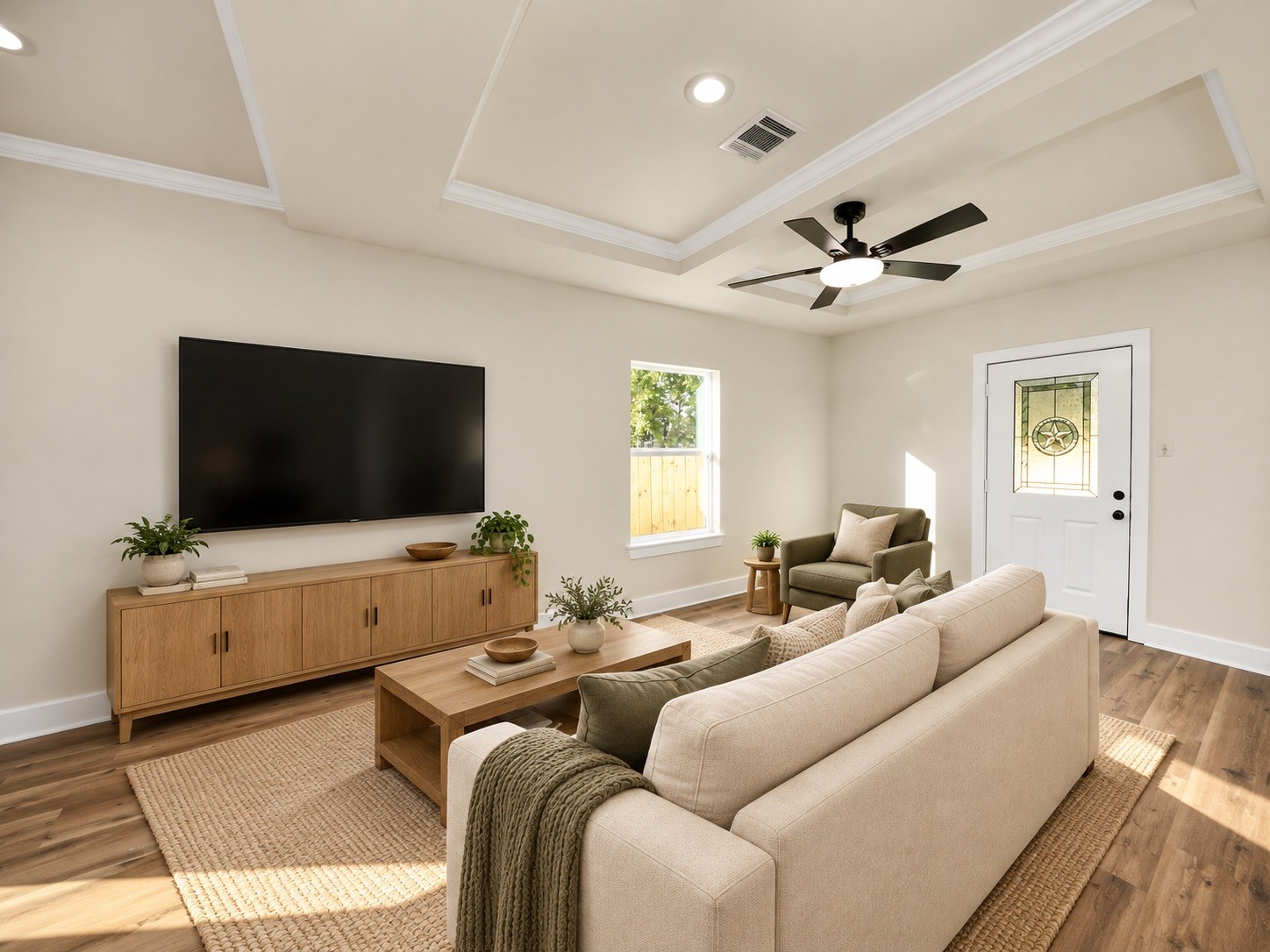 Spacious living room featuring tray ceilings, crown molding, ceiling fan, energy-efficient windows & convenient access to the fully fenced backyard | Virtually staged