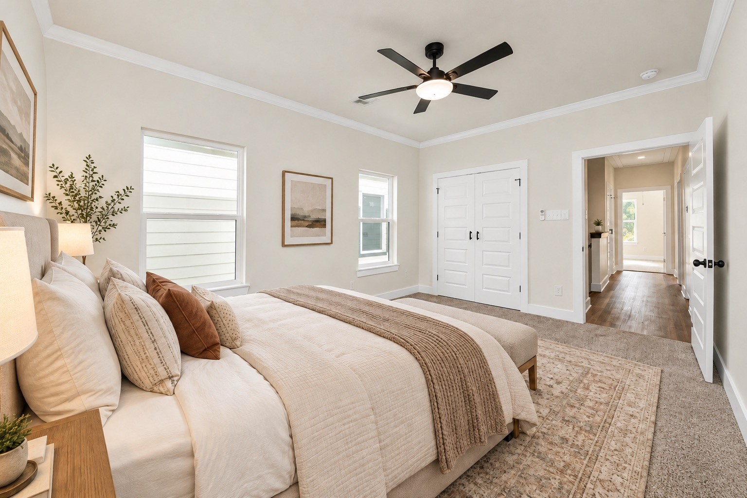Additional view of the private primary suite showcasing its generous dimensions, beautiful ceiling details, neutral finishes & convenient access to the ensuite bathroom | Virtually staged