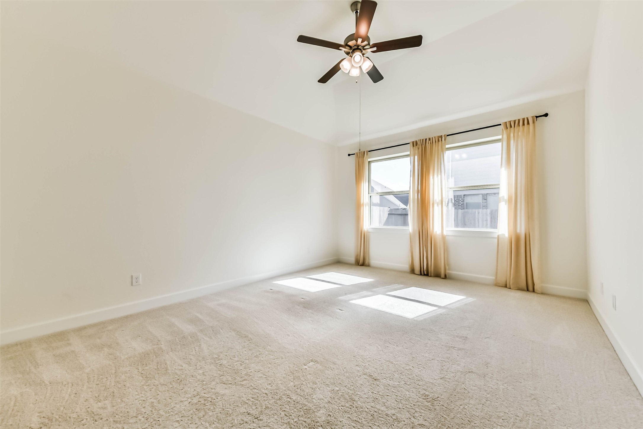 Spacious and inviting Primary bedroom with abundant natural light, featuring a cozy bed, elegant dresser, and plush carpeting for ultimate comfort.