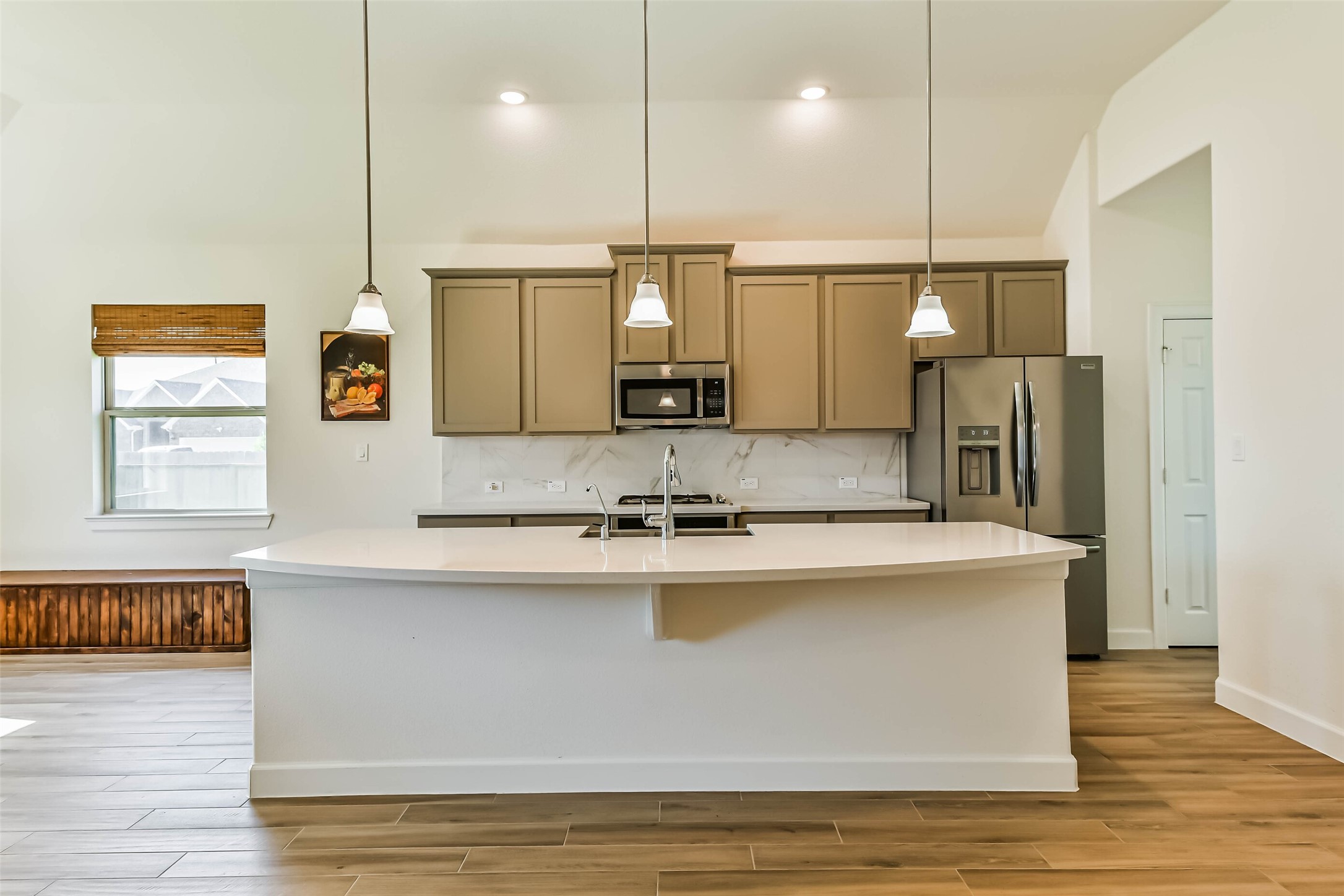 Modern kitchen with sleek cabinetry, stainless steel appliances, and a spacious island with pendant lighting, perfect for entertaining.
