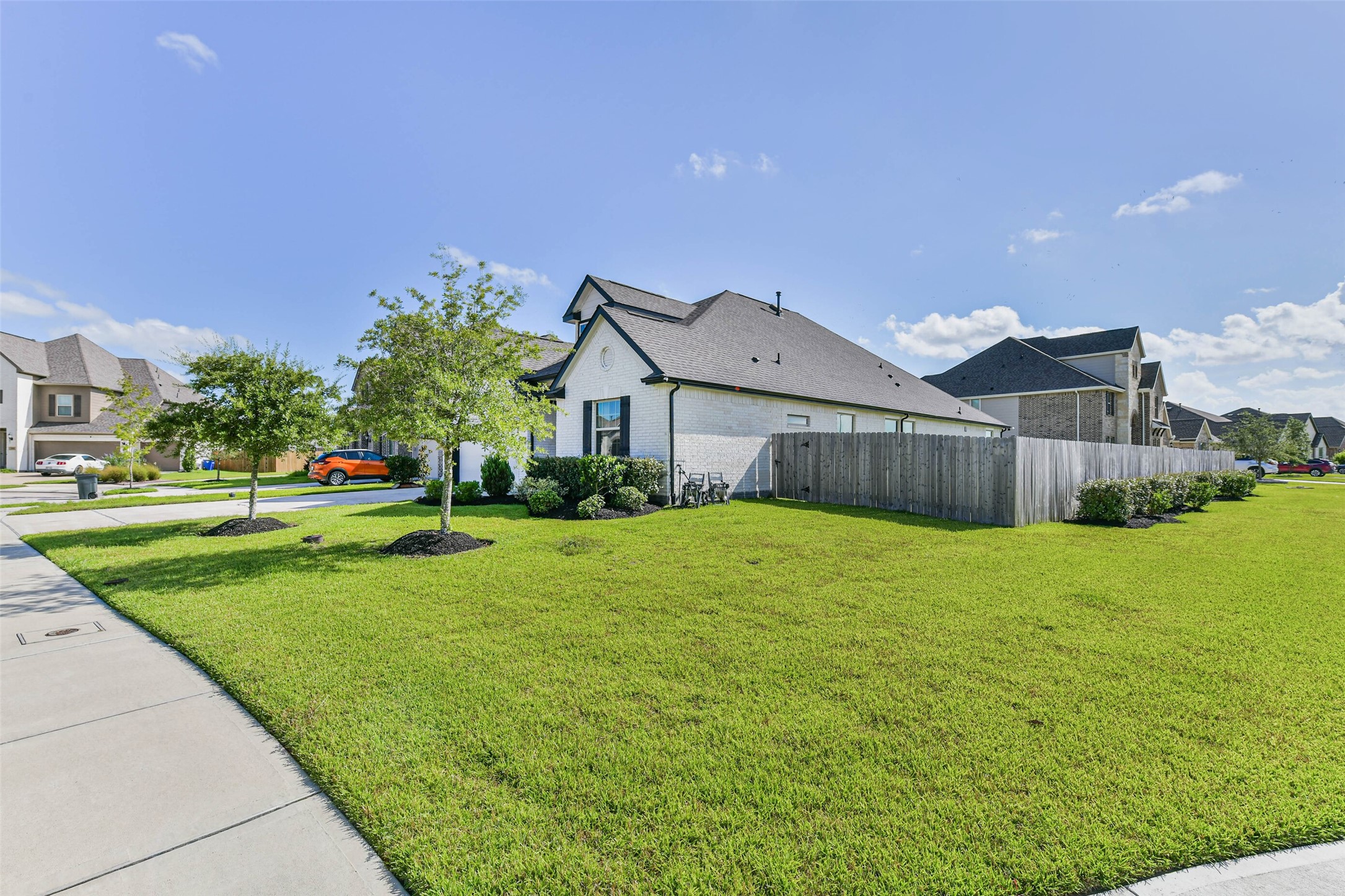 Charming modern home on a spacious corner lot, featuring a well-maintained lawn and a cozy fenced backyard in a peaceful neighborhood.