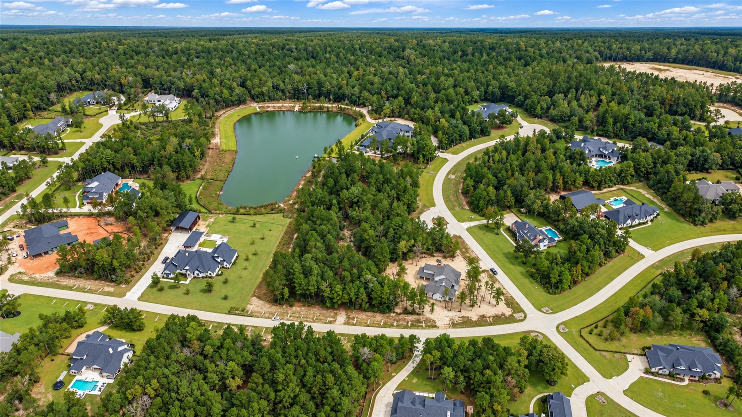 A broader neighborhood view showcases the nearby lake and surrounding wooded homesites. A broader neighborhood view showcases the nearby lake and surrounding wooded homesites.