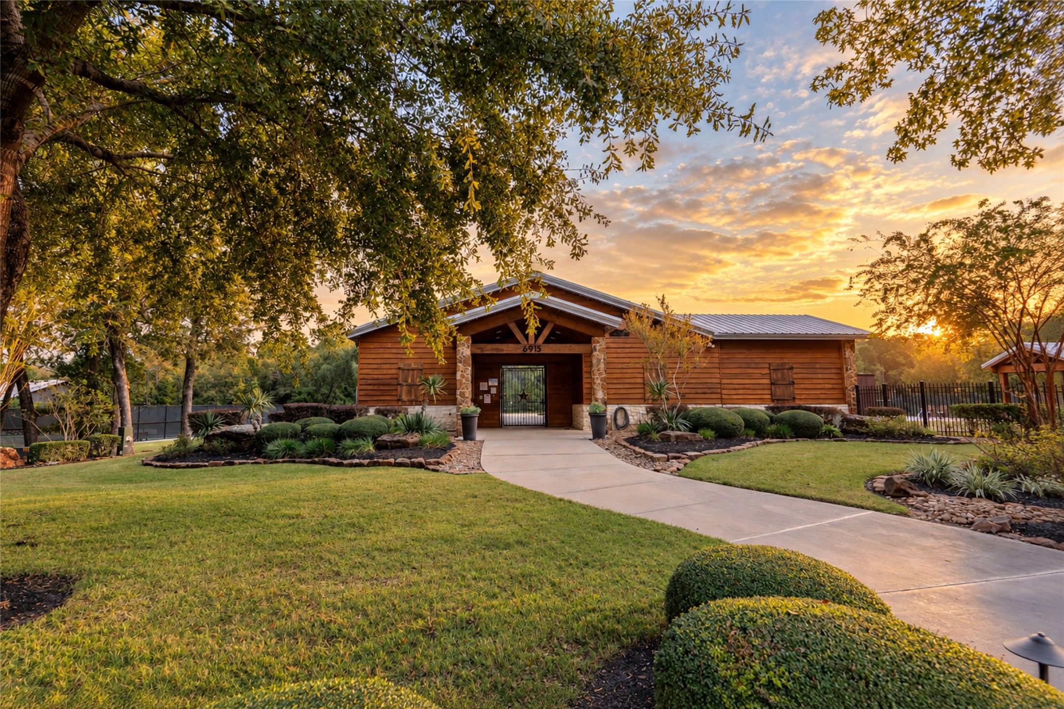 Community gathering space surrounded by established trees and landscaped grounds.