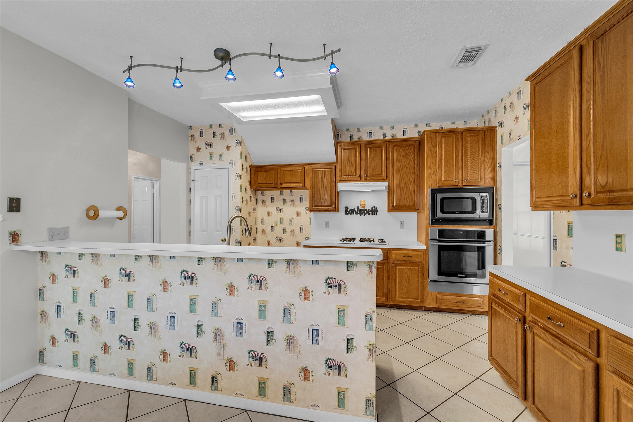 Charming kitchen with classic wooden cabinetry with a cozy breakfast bar.