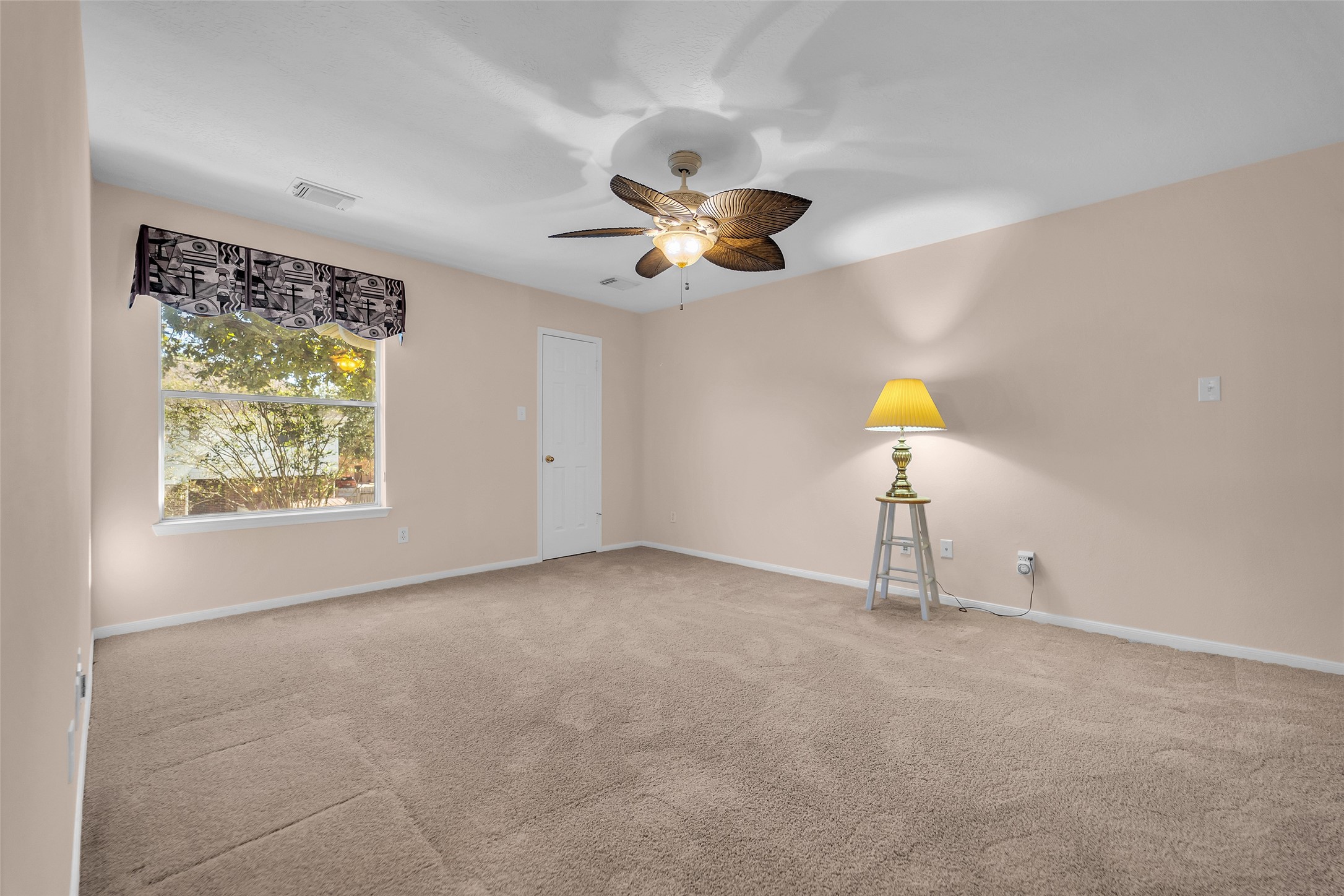 Spacious game room with neutral walls and carpet.