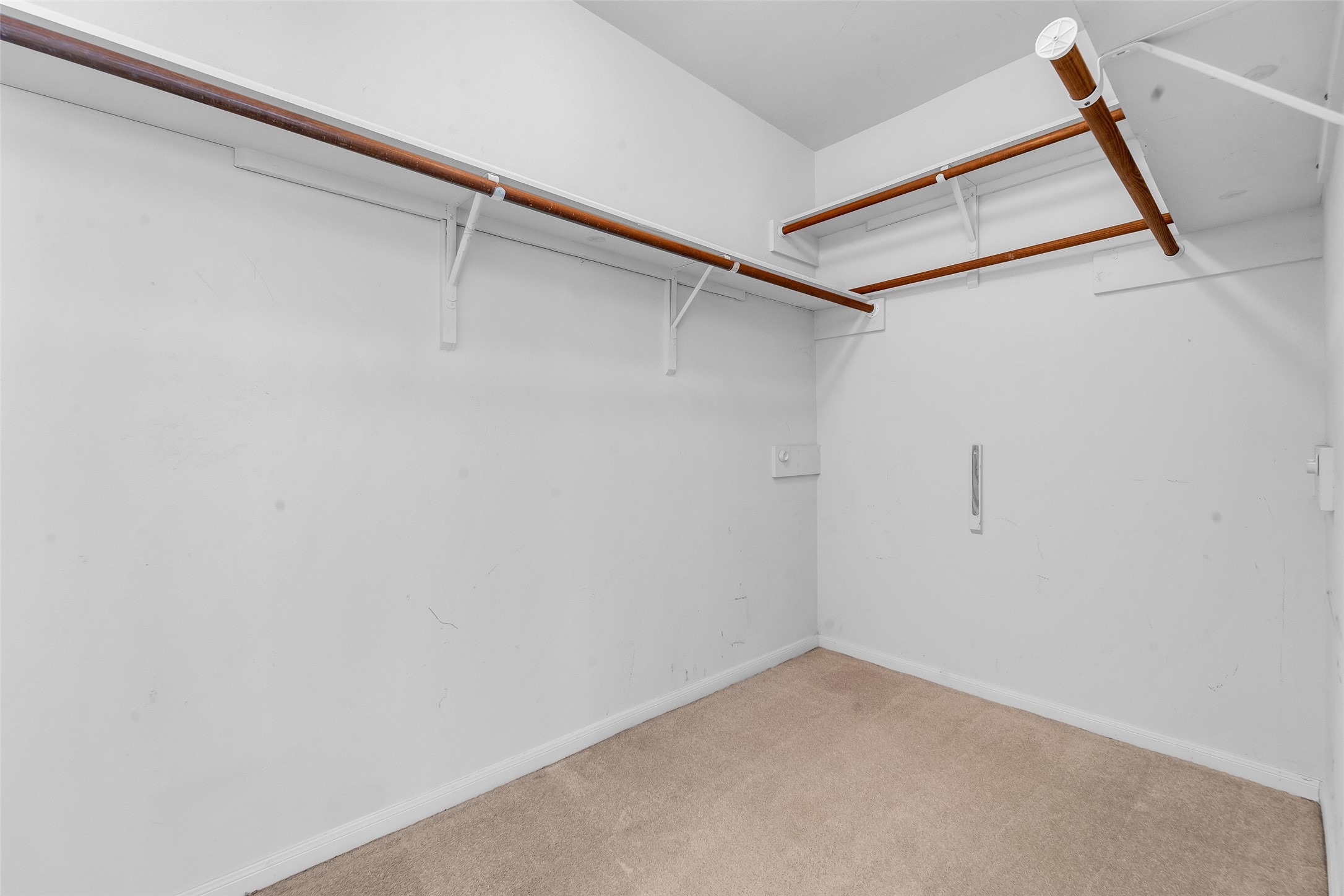 Spacious walk-in closet with dual-level shelving and ample hanging space, perfect for organizing your wardrobe. 1 of 2 closets in the primary.