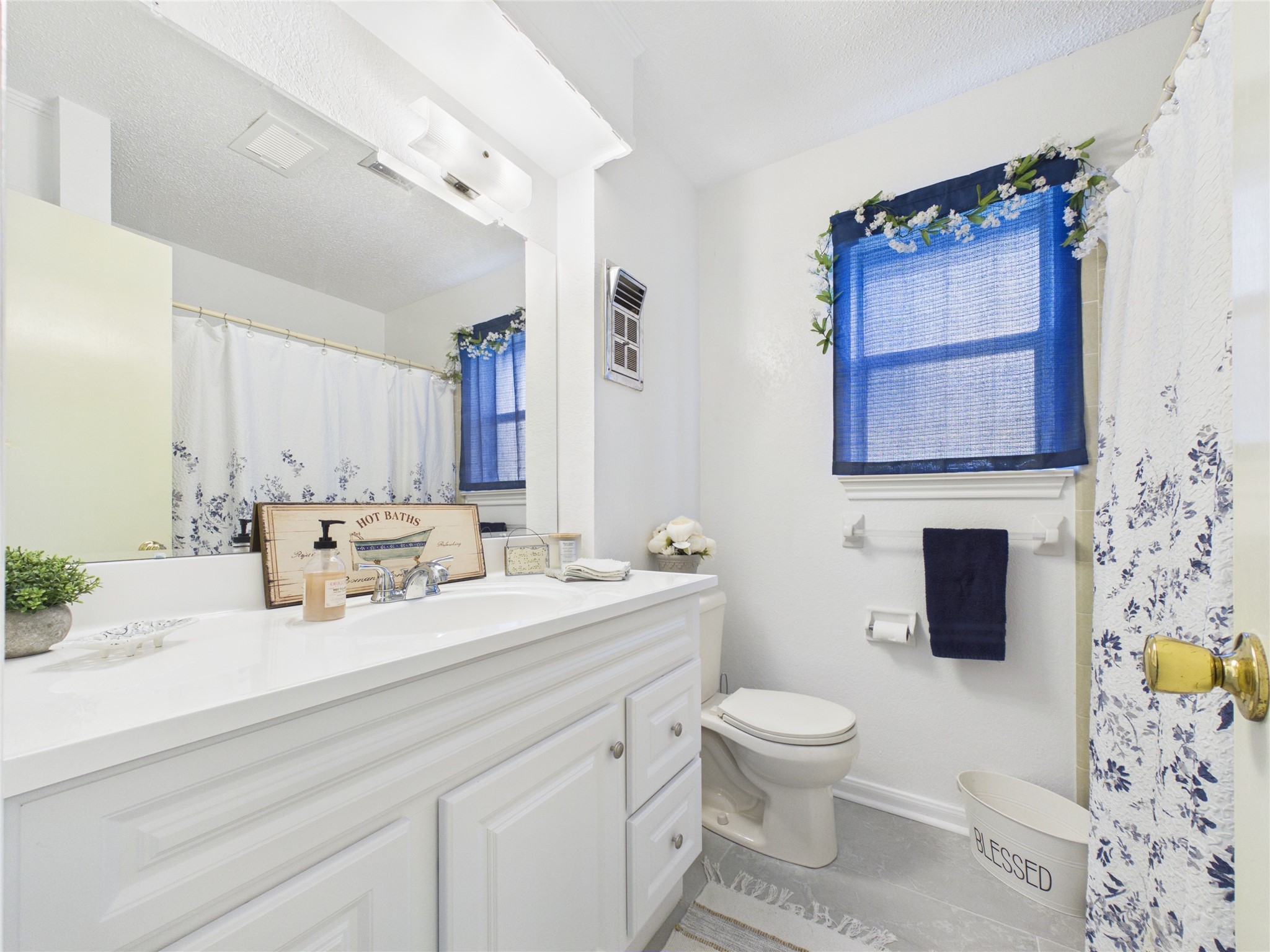 Secondary bathroom with recent updates: vanity, tile floors, plumbing fixtures.  There's also a linen closet behind the door offering plenty of storage for linens, towels, supplies.