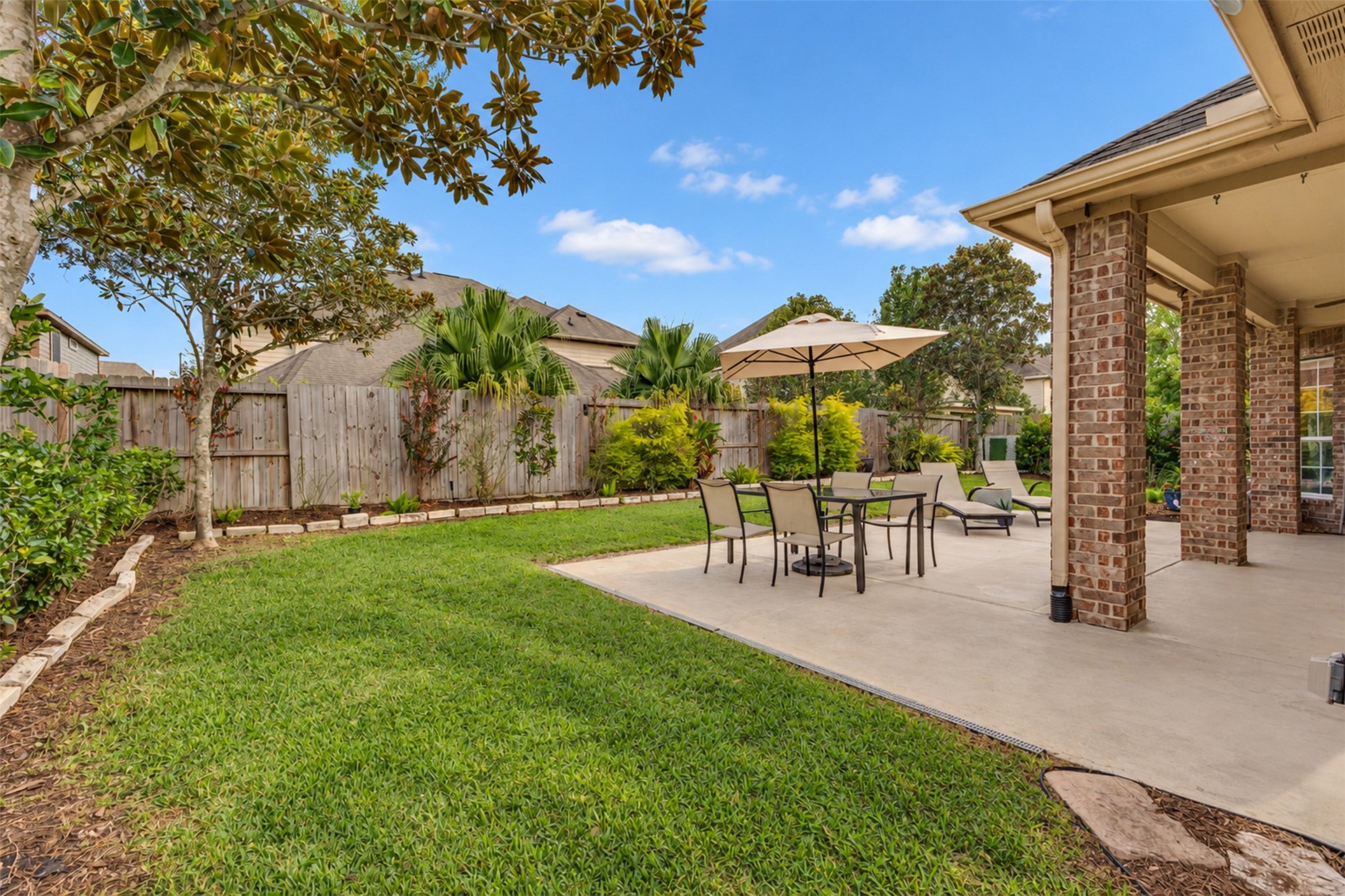 Beautifully landscaped backyard with lush greenery, mature trees, and plenty of room to relax or entertain.