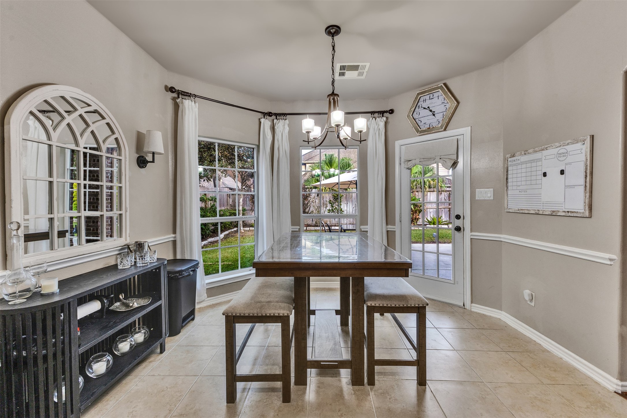 Start your mornings with coffee and sunshine in this charming breakfast area overlooking the backyard oasis.