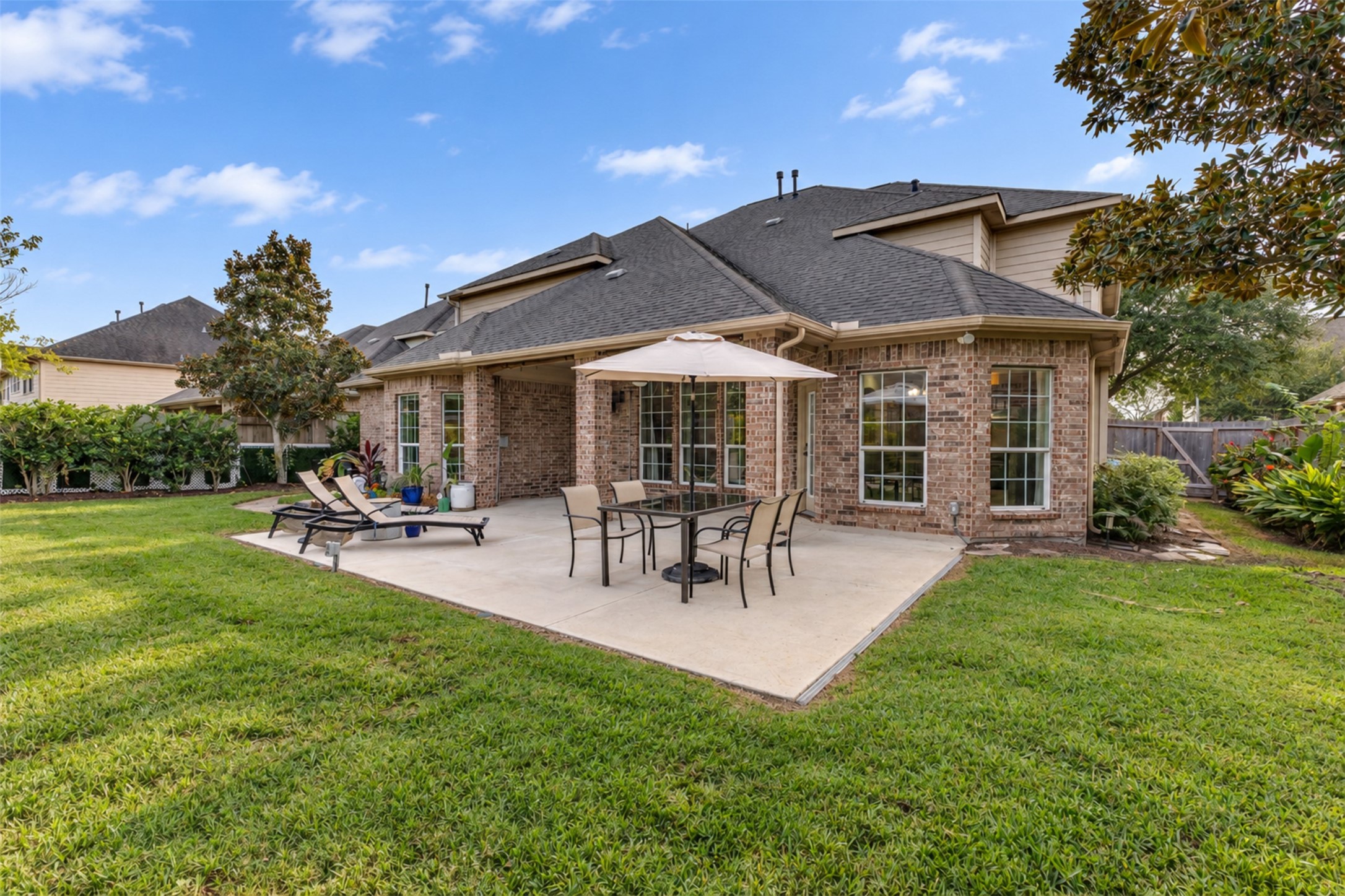 An expansive patio and manicured lawn create a wonderful setting for gatherings and outdoor activities.