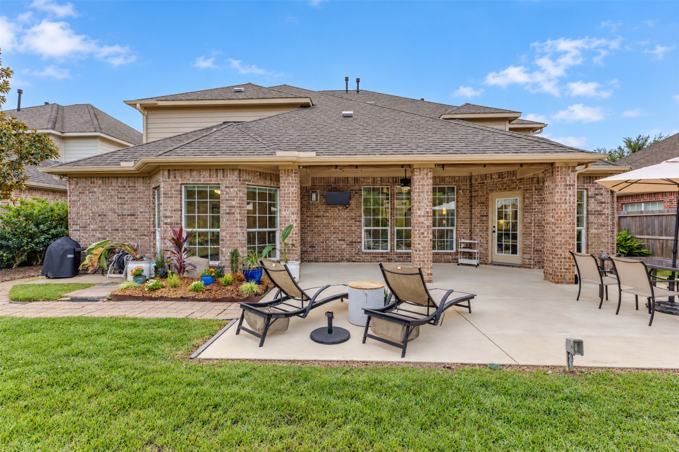 Enjoy the generous covered patio with ceiling fans, outdoor TV, and multiple seating areas.
