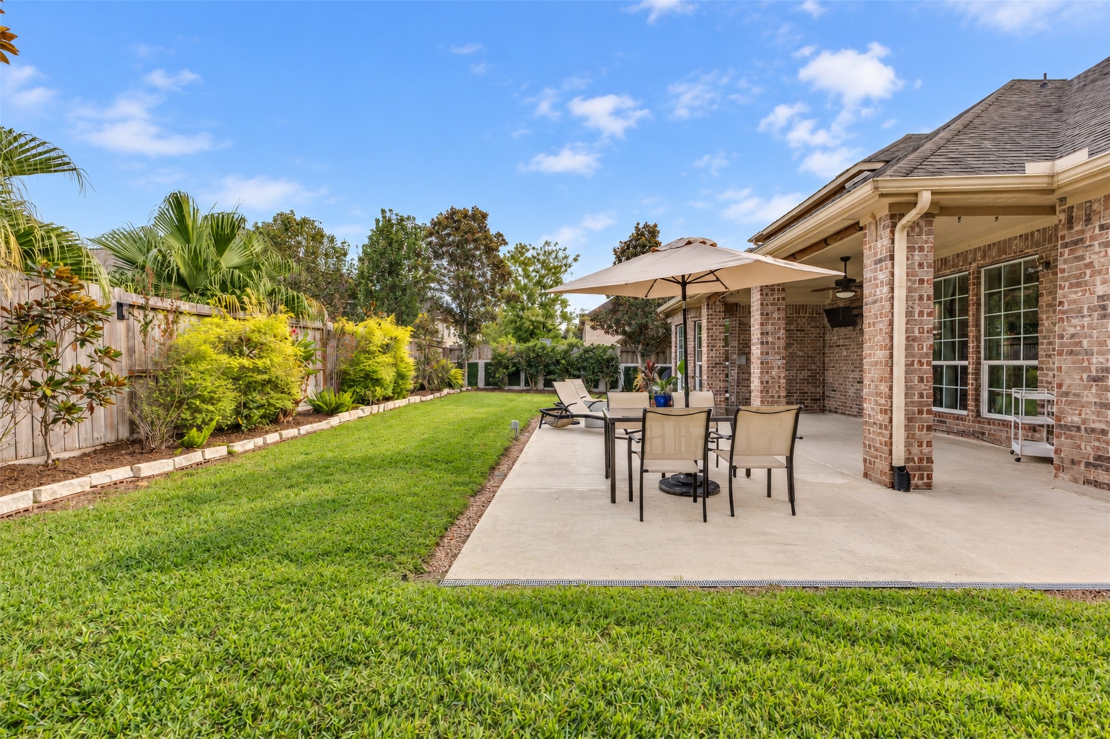 Spacious patio with room for outdoor dining, lounging, and enjoying the backyard.