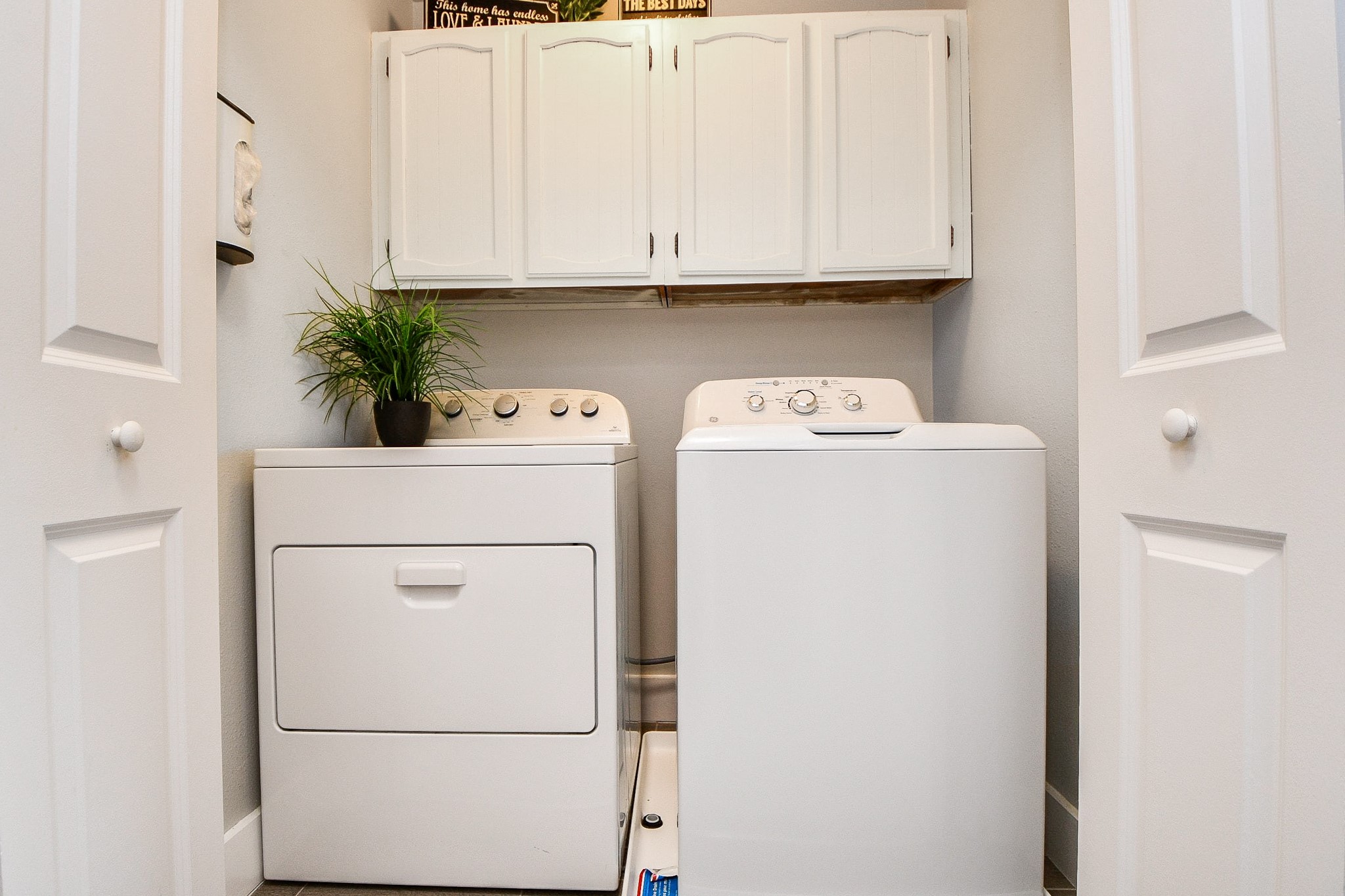The utility room includes white upper cabinets for added storage.