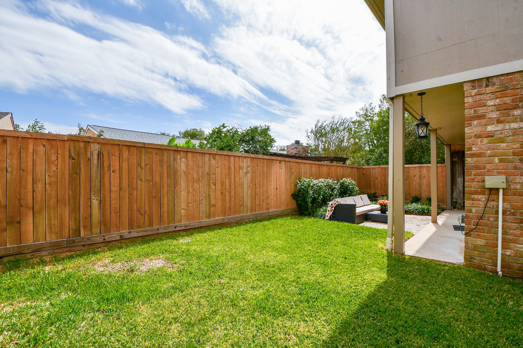 The lawn wraps around the home, all enclosed by cedar fencing.