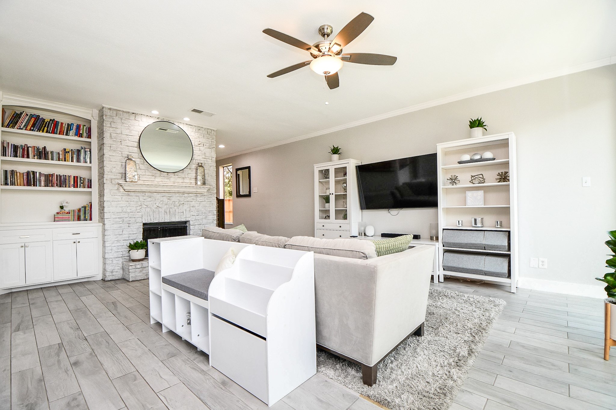 Built-in bookshelves flank a whitewashed brick fireplace in the living room.