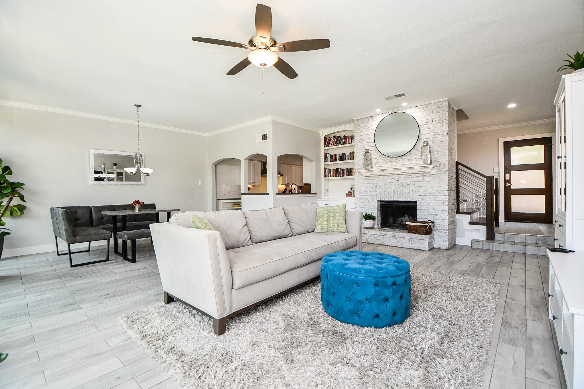 The living room is the bright, open heart of the home, connecting the fireplace, dining area, and entry.