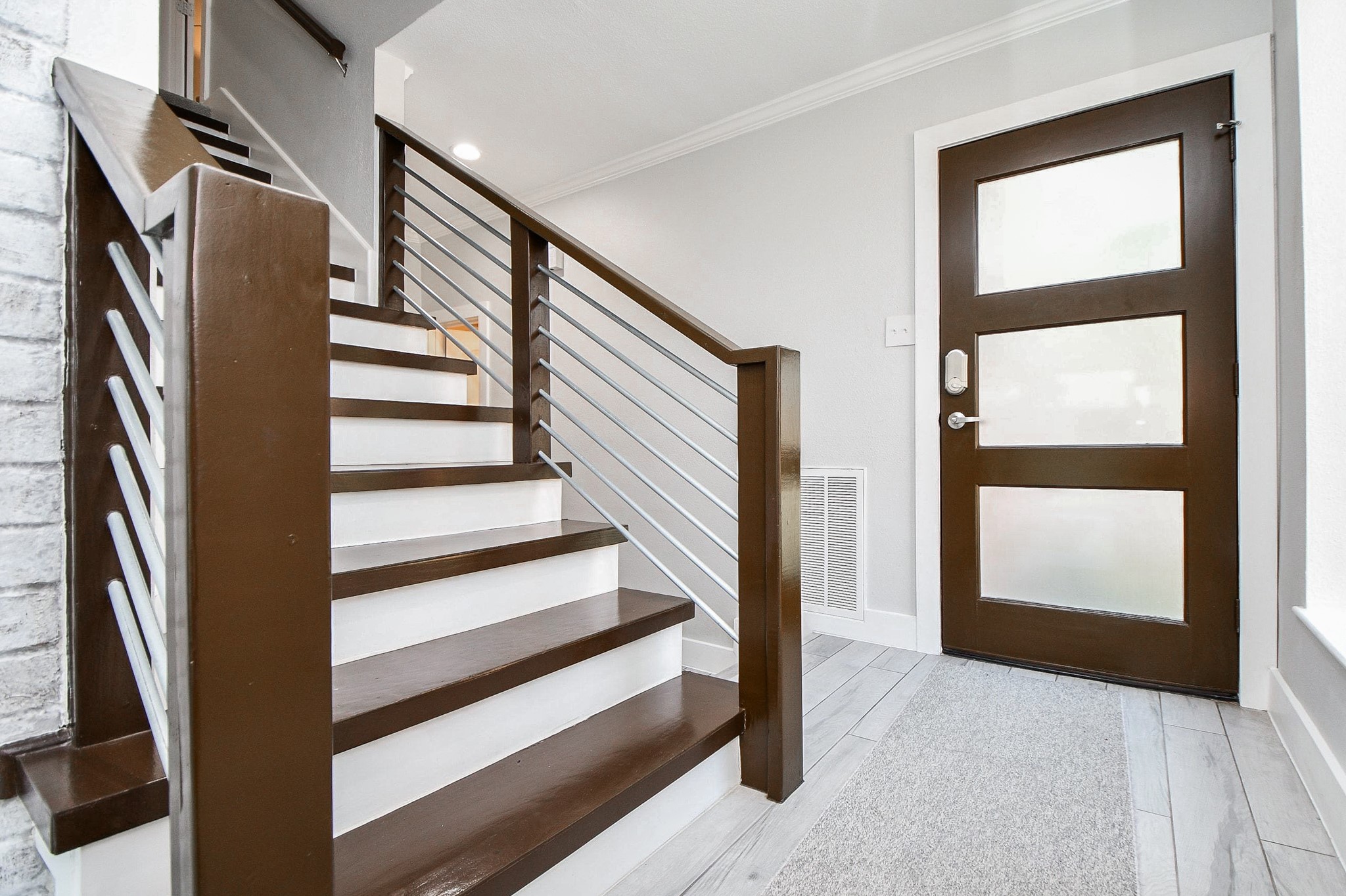 The contemporary front door has frosted glass panels and a keyless smart lock.