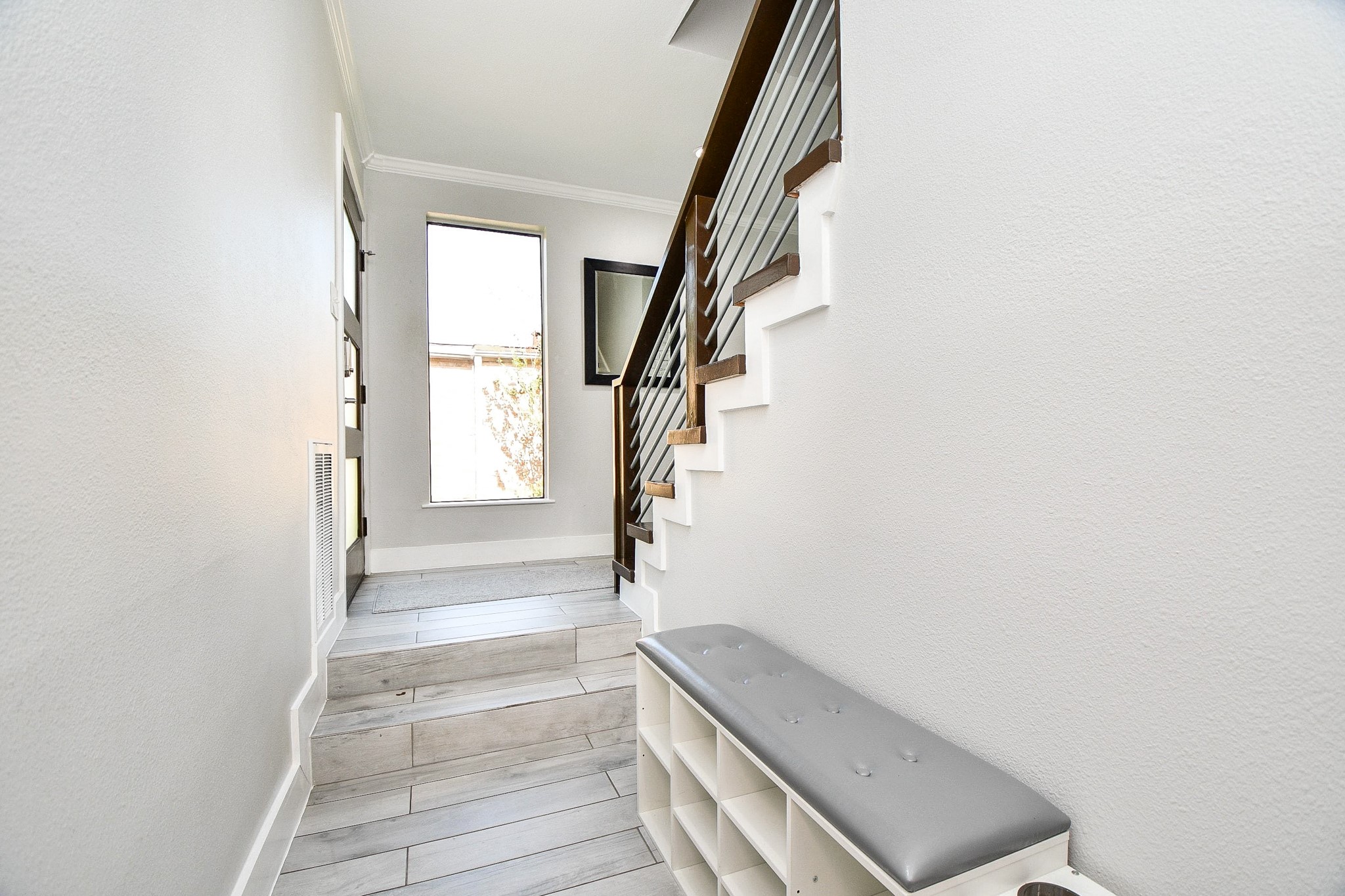 The downstairs landing at entry is brightened by a tall window.