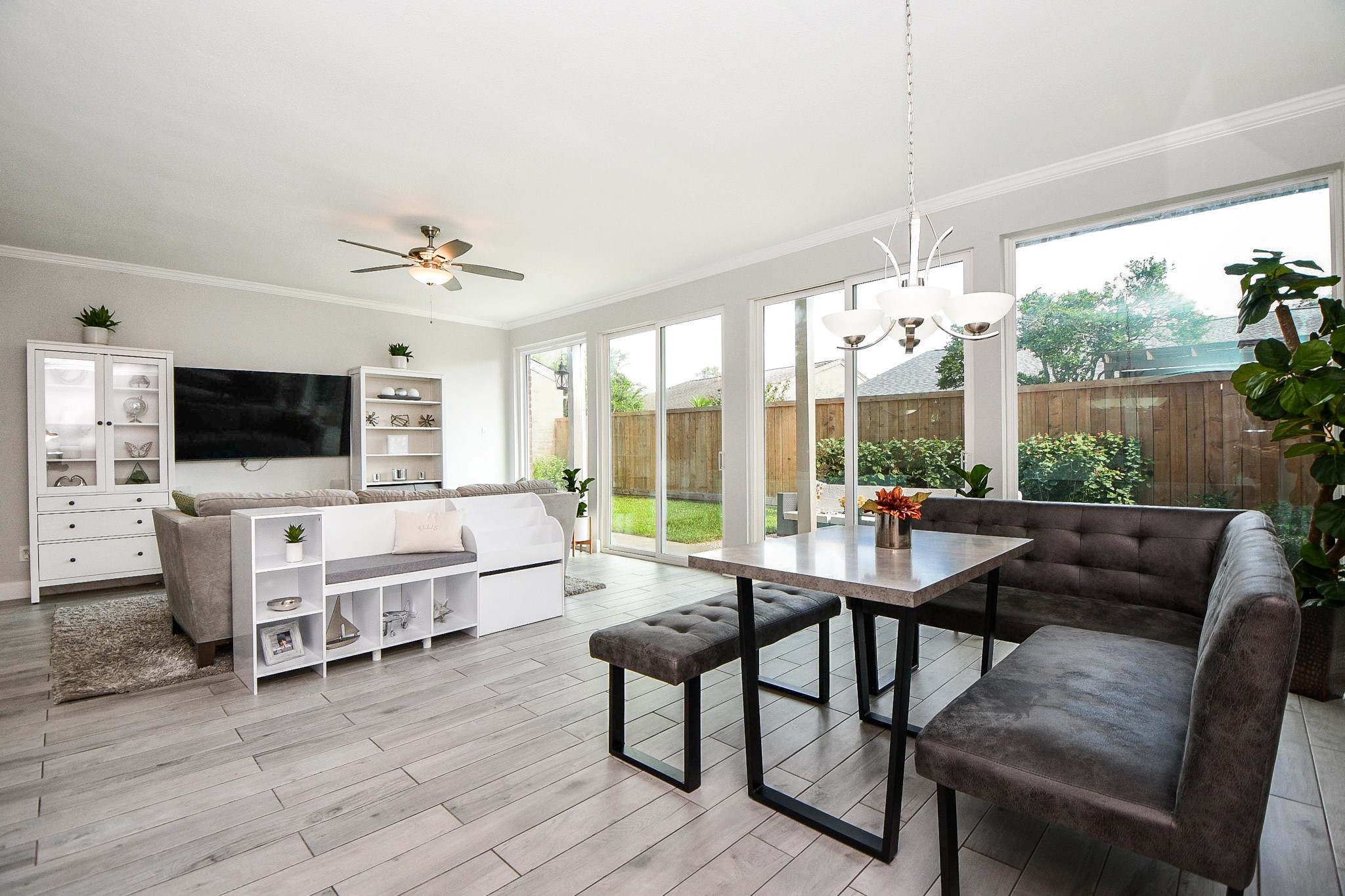 The open-concept living and dining area is filled with natural light from a wall of windows.